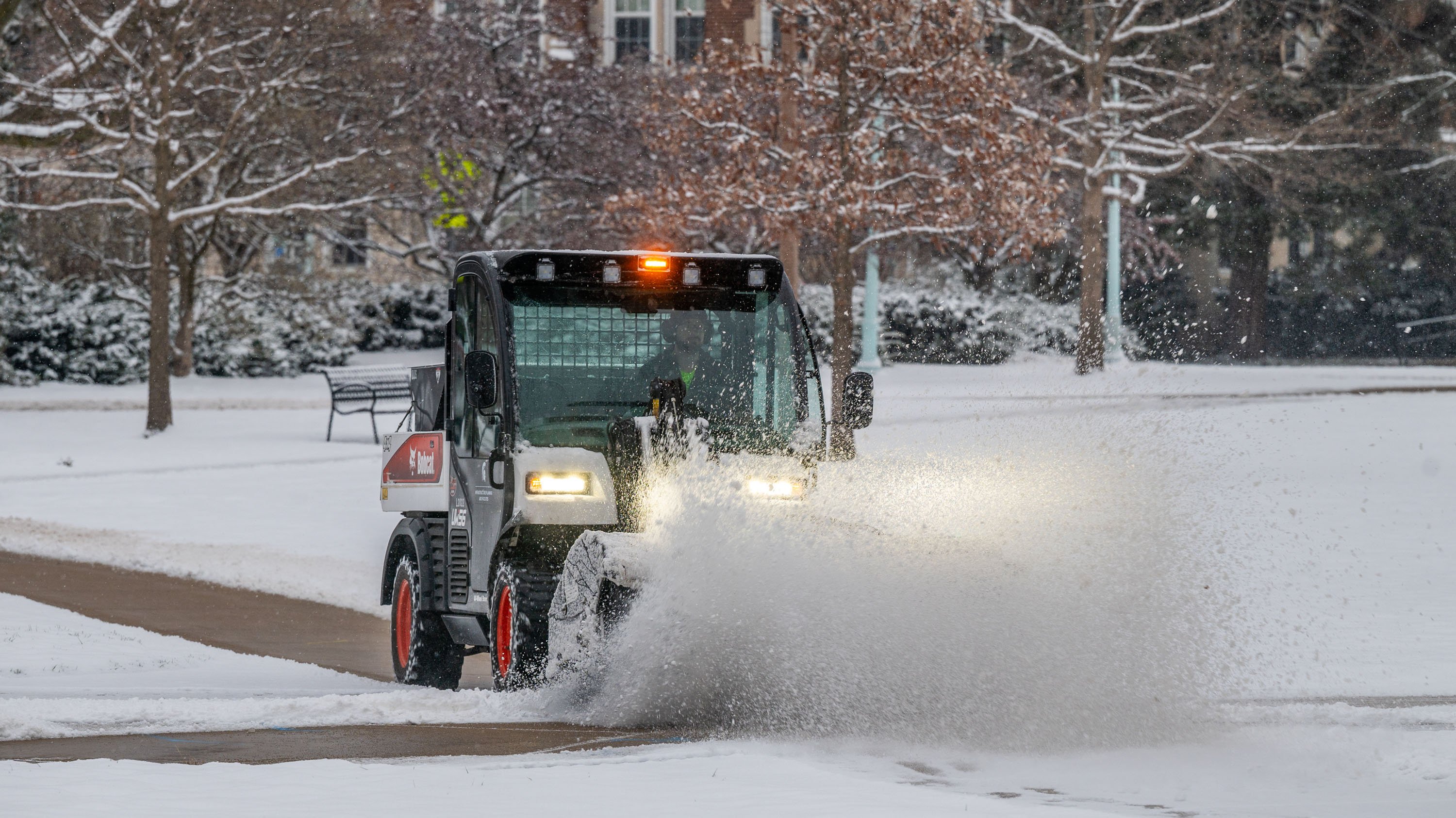 Snow plow removing snow from sidewalk