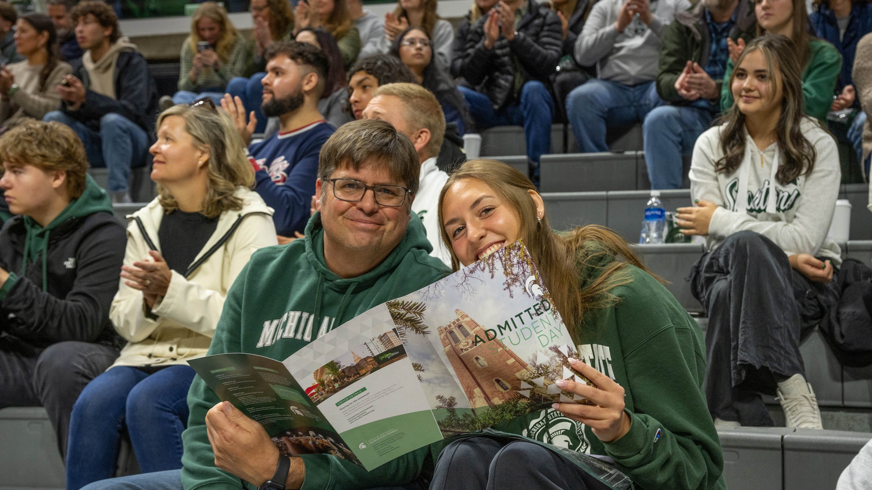 Parent and student holding admitted students day program in Breslin Center