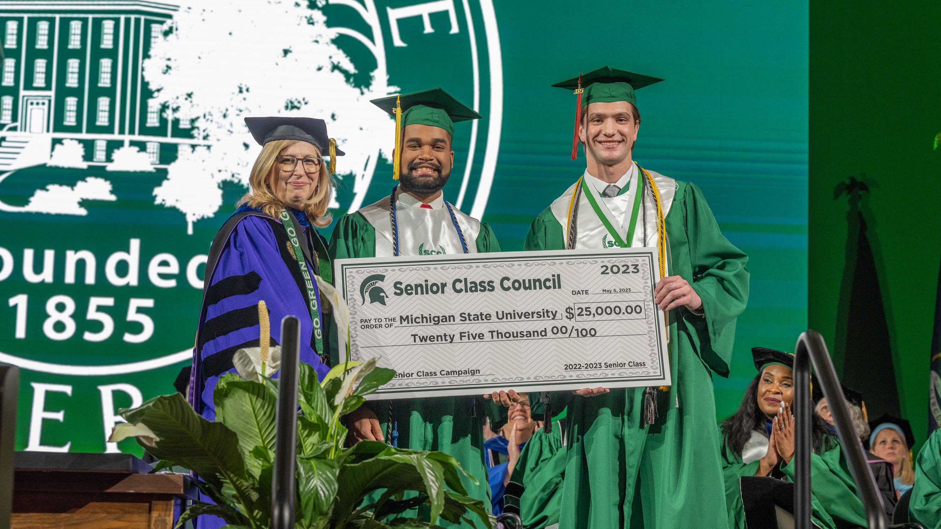 Theresa K. Woodruff and students with 2023 Senior Class Council check at commencement