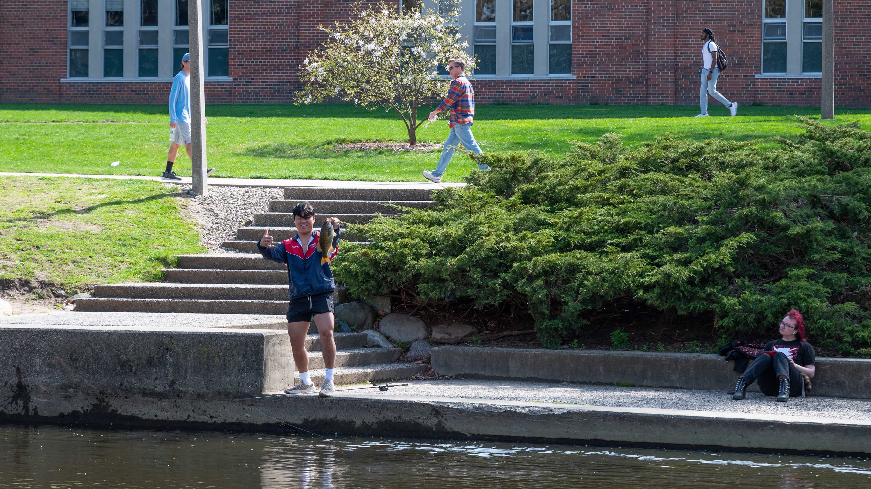 Student with caught fish on red cedar river