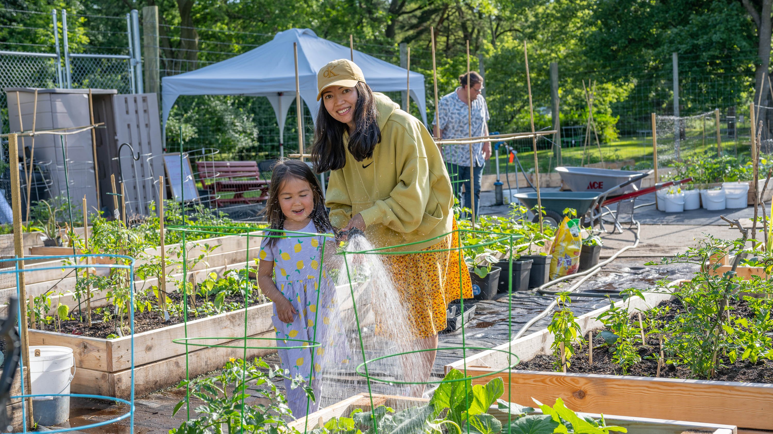 Mother and daughter watering plants in 1855 Place Community Garden