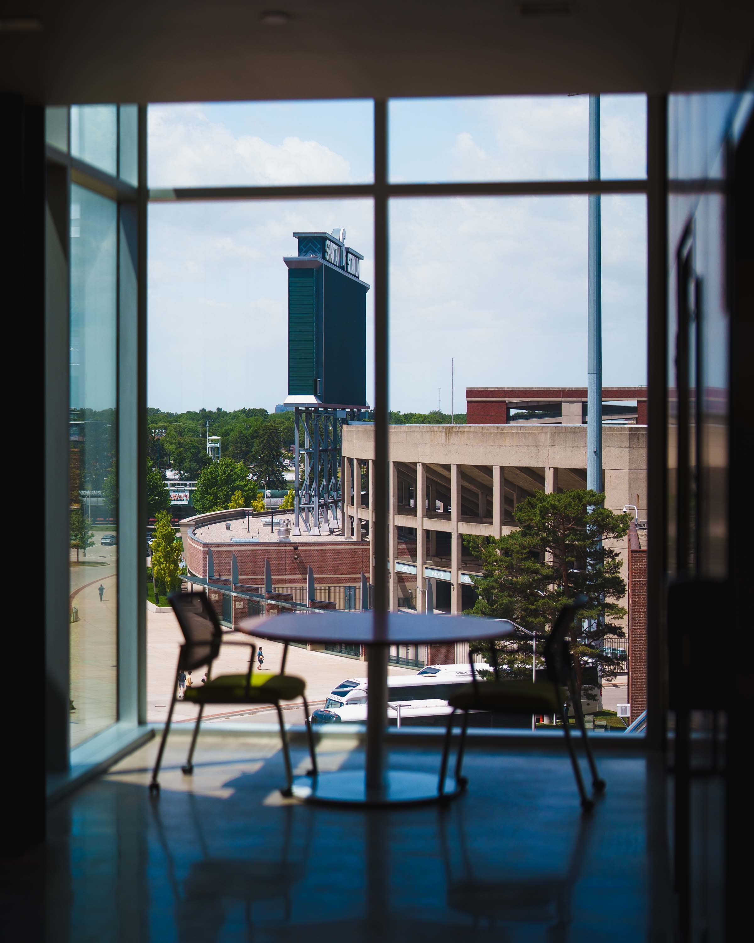 Table and chairs in front of window, with view of Spartan Stadium