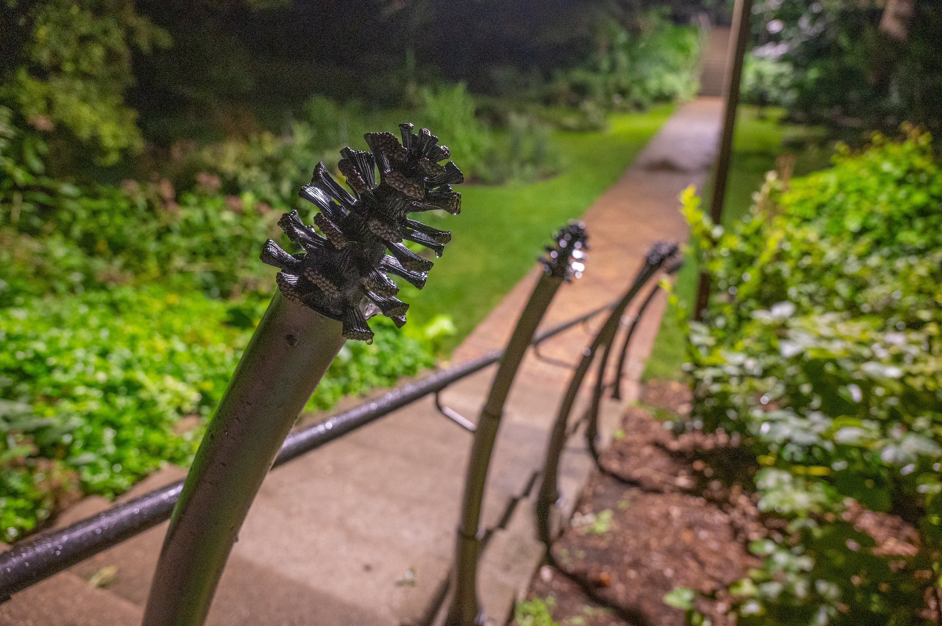 Pinecones at the top of fence posts leading to Beal Botanical Garden.