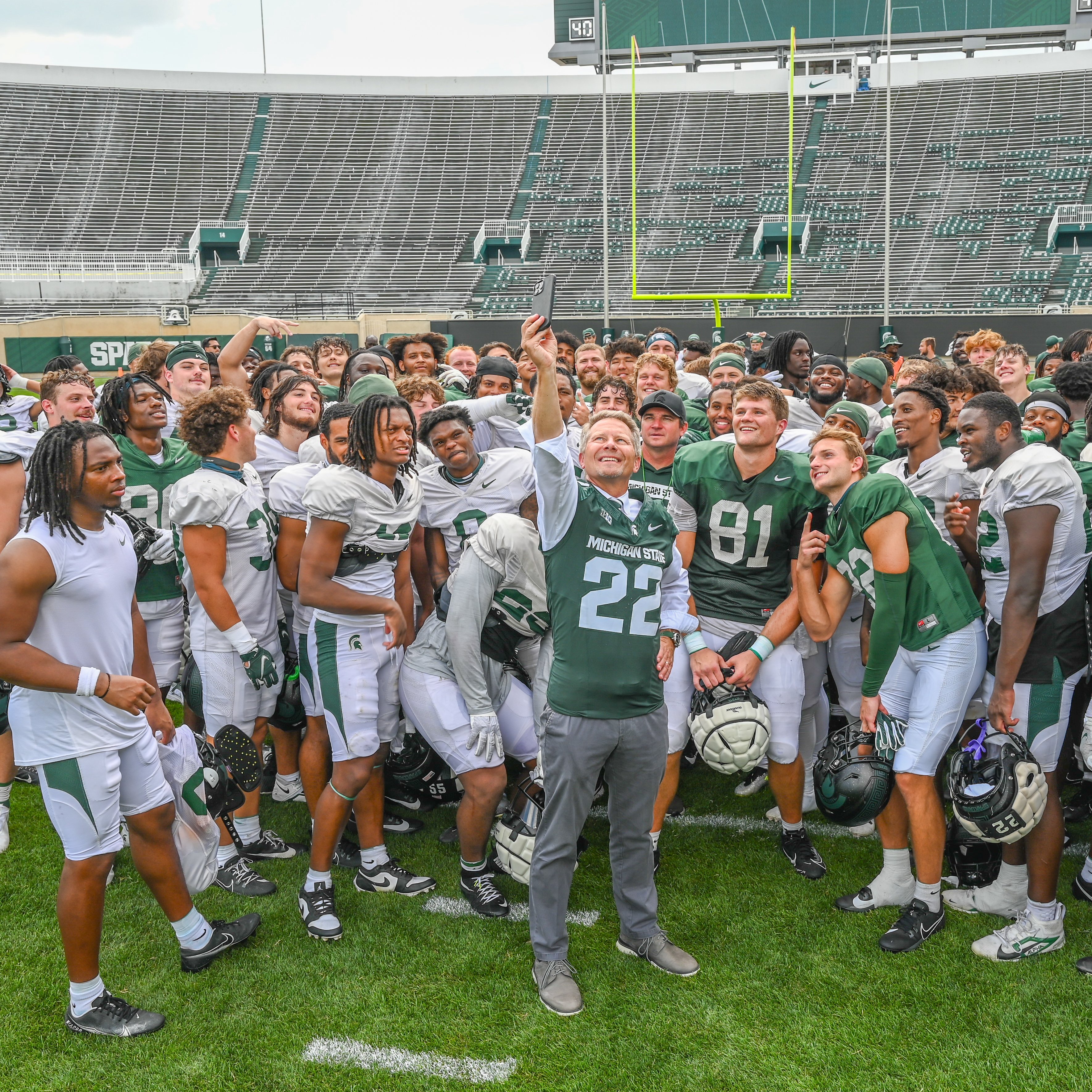 President Kevin Guskiewicz takes a selfie with the football team at Spartan Stadium.