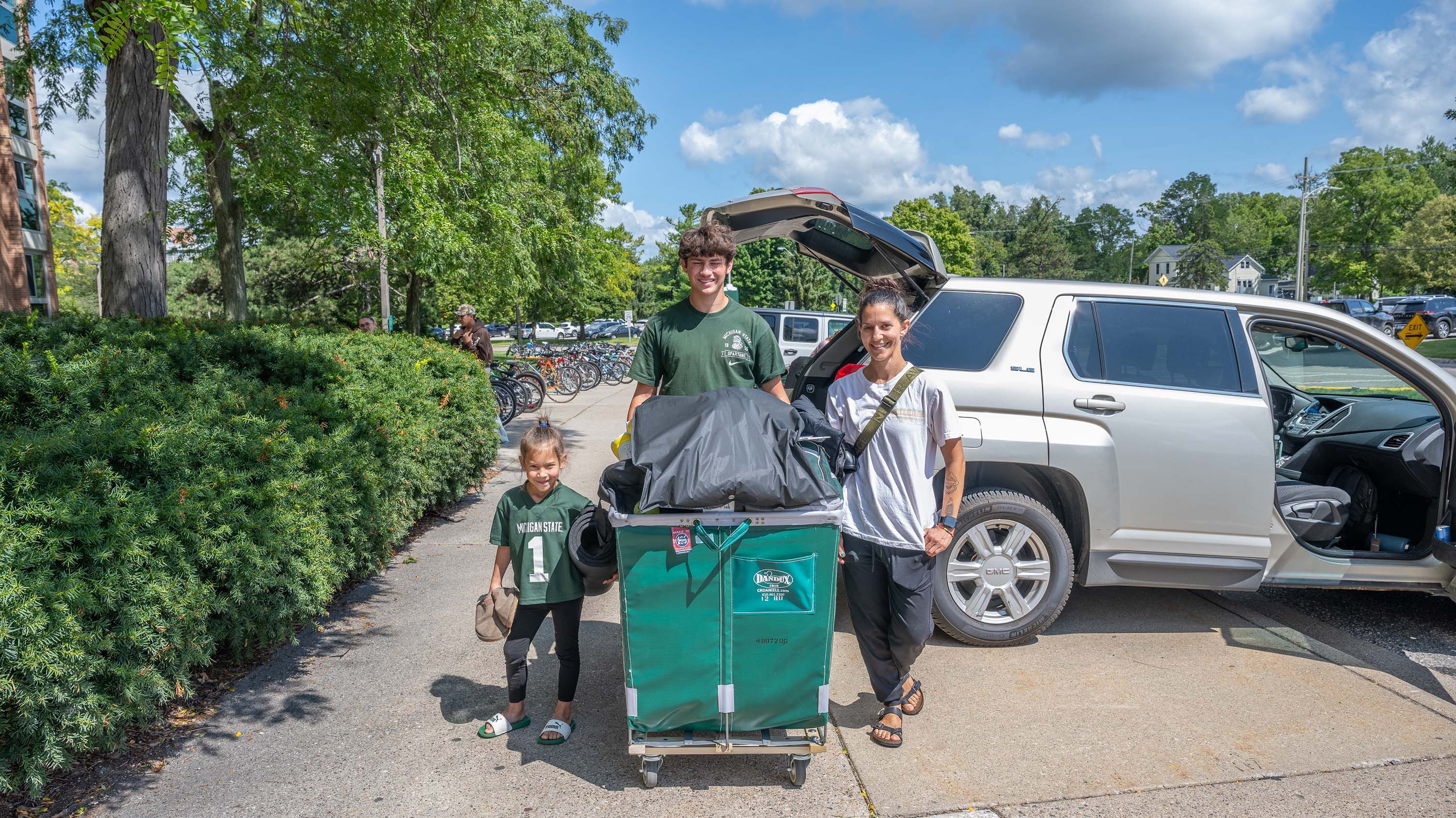 Student and family with laundry cart at move in