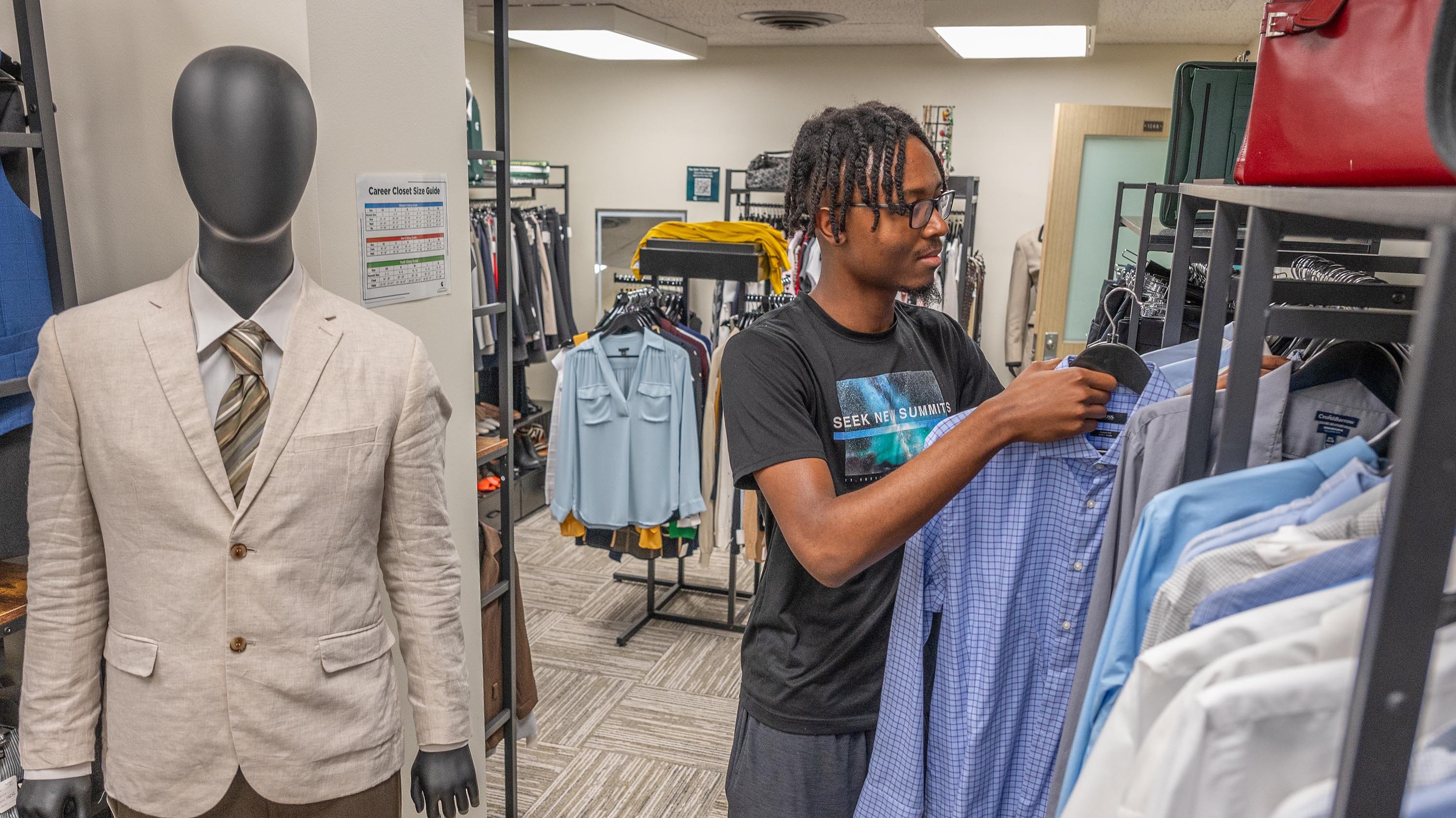 Student hanging up dress shirt in Career Closet