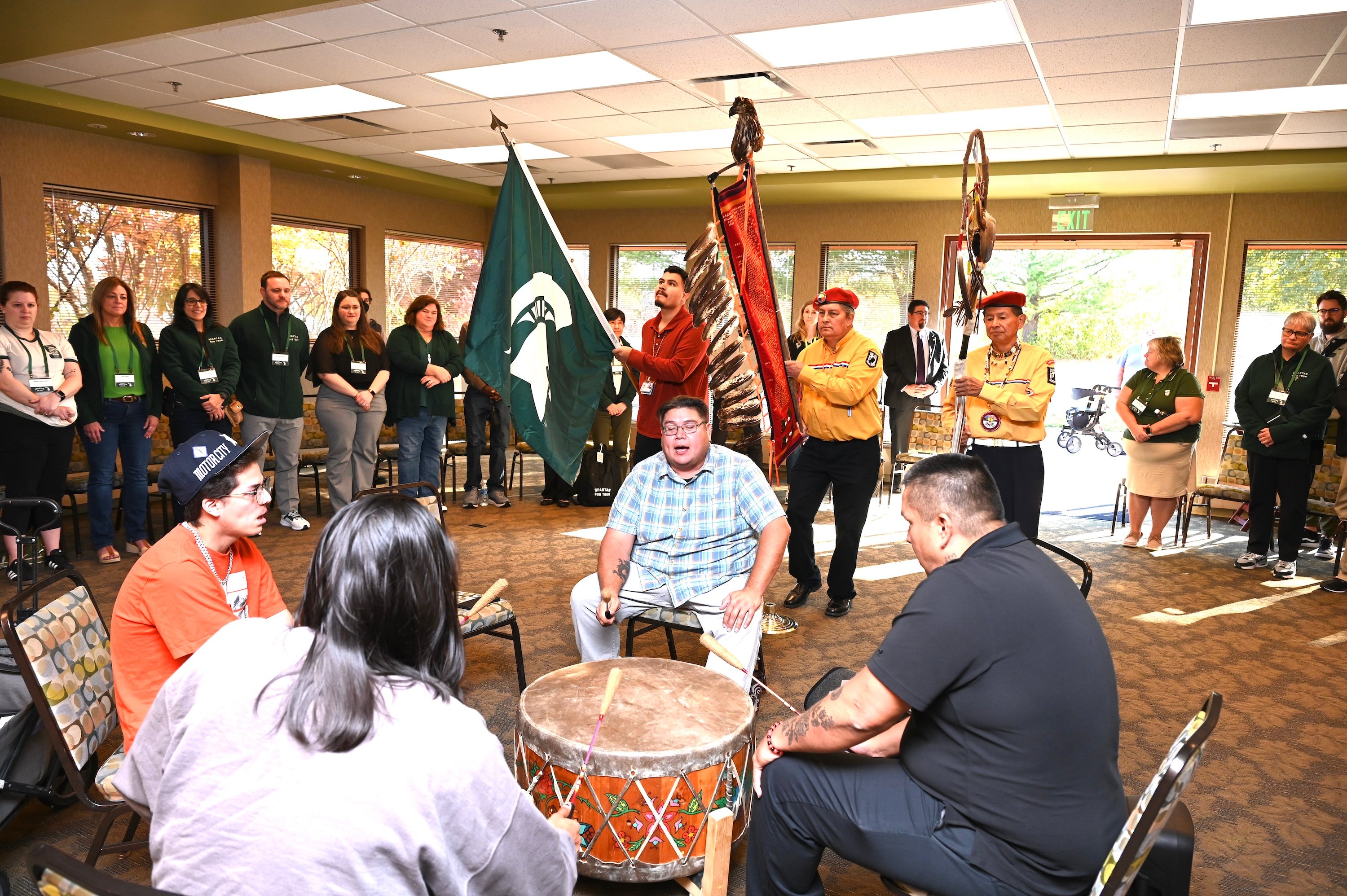 The Saginaw Chippewa Indian Tribe?s Onion Creek Singers play a traditional drum song in front of members of the Spartan Bus Tour.