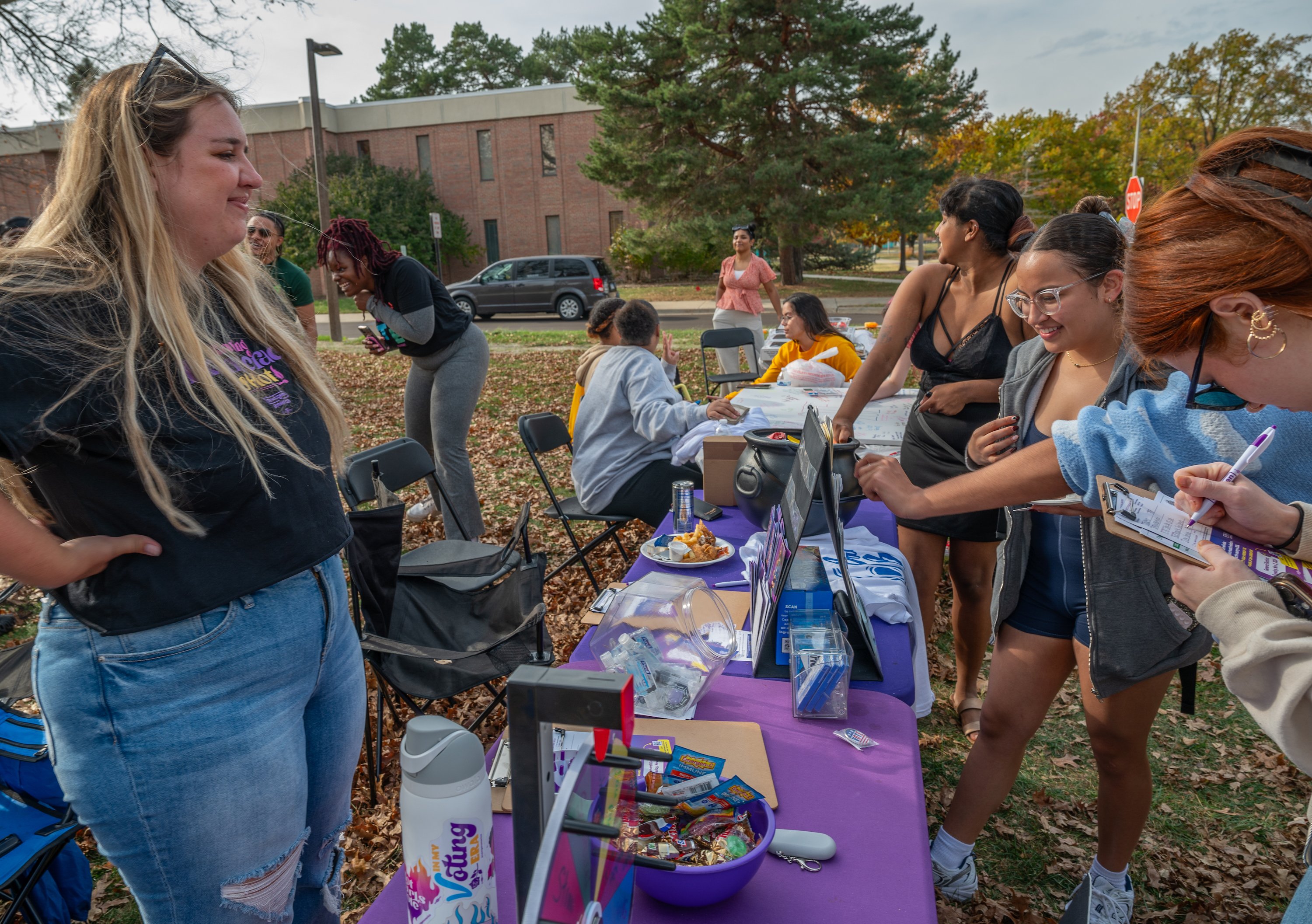 Individuals gather around a table at a voting rally held on MSU's campus.