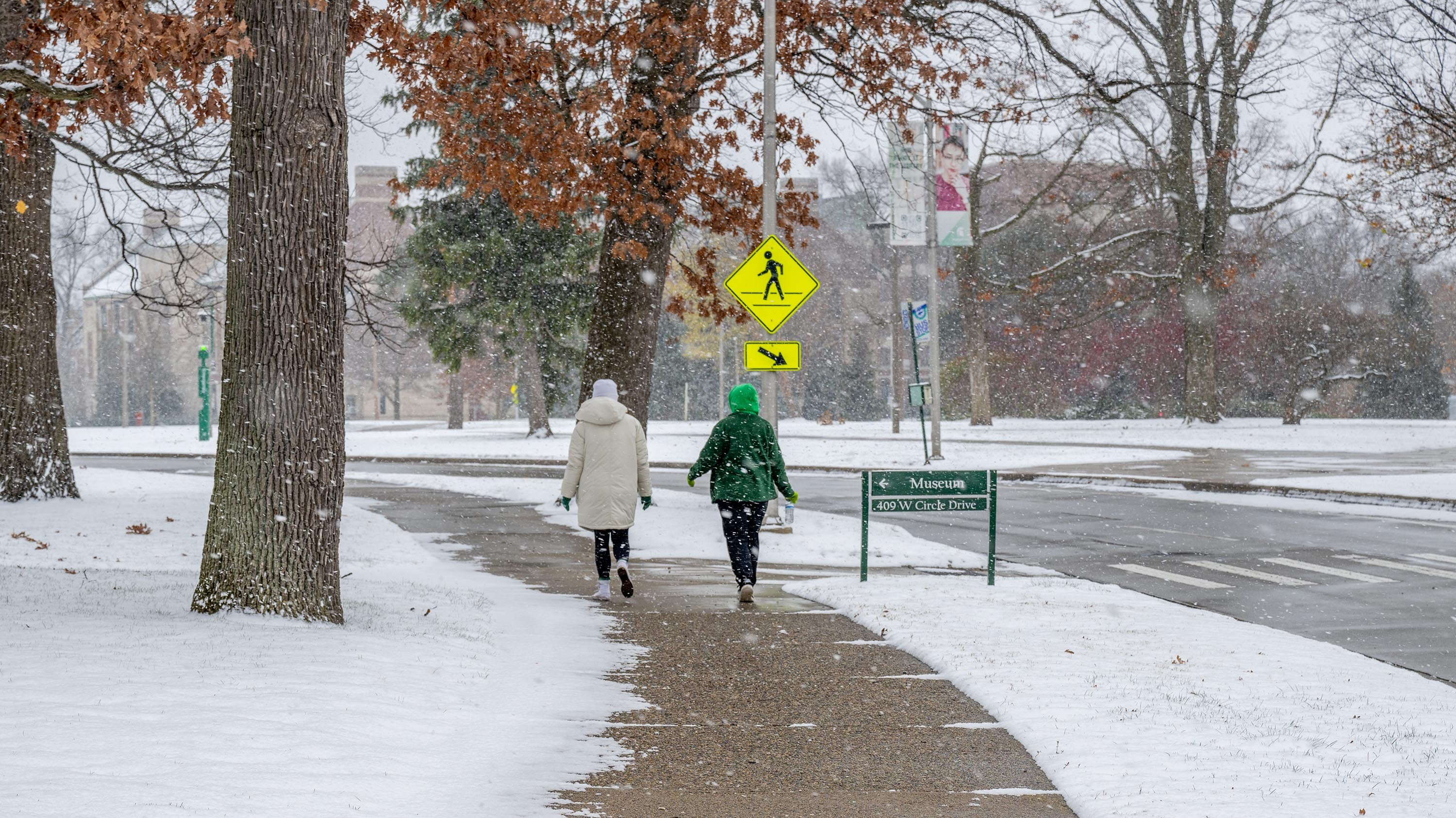 People in green and white clothes walking in snow
