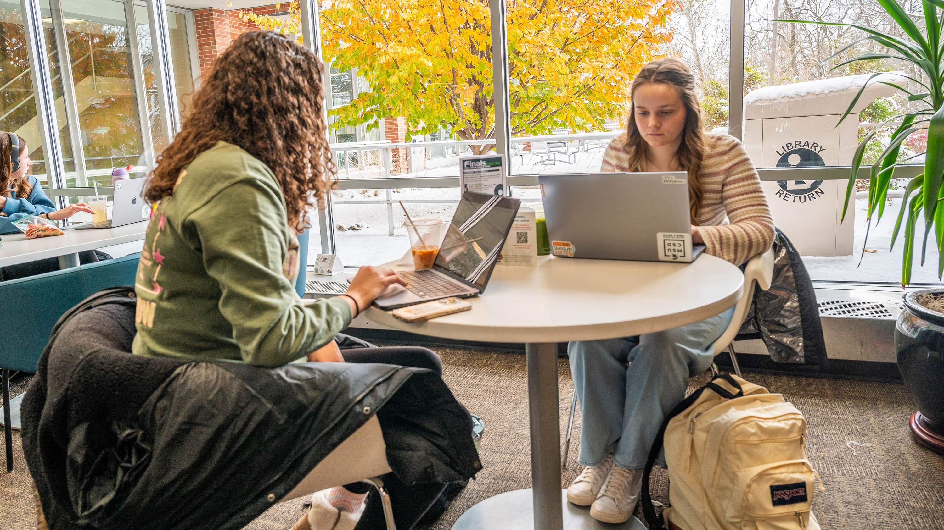 Two students studying at a small table
