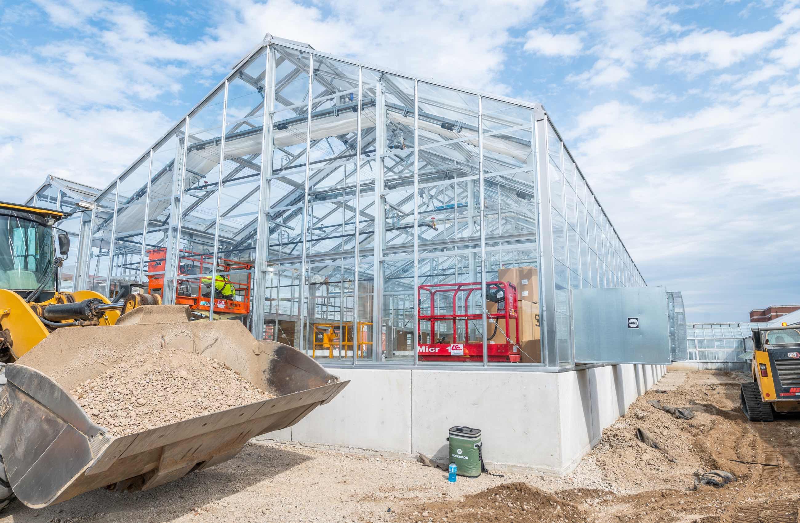 Exterior of a greenhouse under construction.