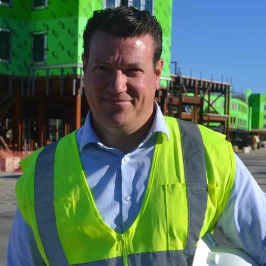 A person in a construction vest at a construction site.