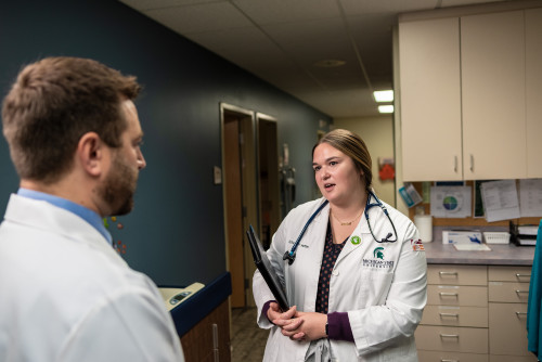 Elizabeth Martin, a fourth-year College of Human Medicine student, speaks with physician David Buzanoski