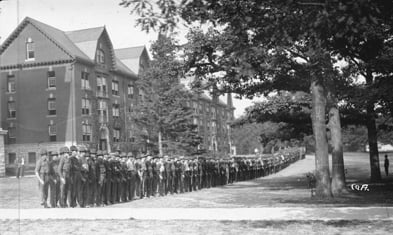 Student Army Training Corps (S.A.T.C.) students stand in formation in front of Wells Hall in 1918. 