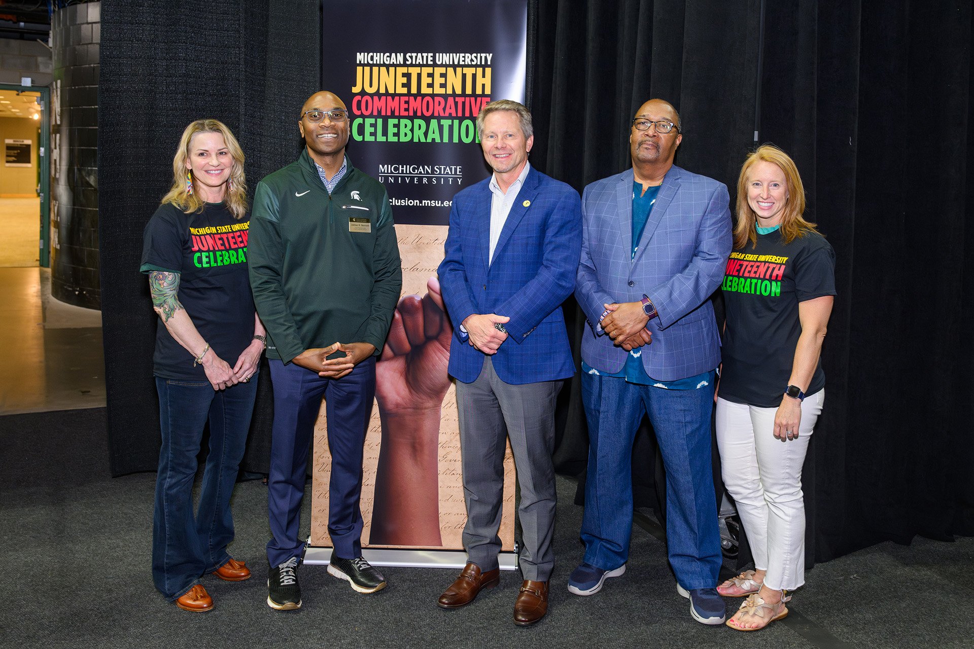 MSU leaders take a photo in front of a Juneteenth banner