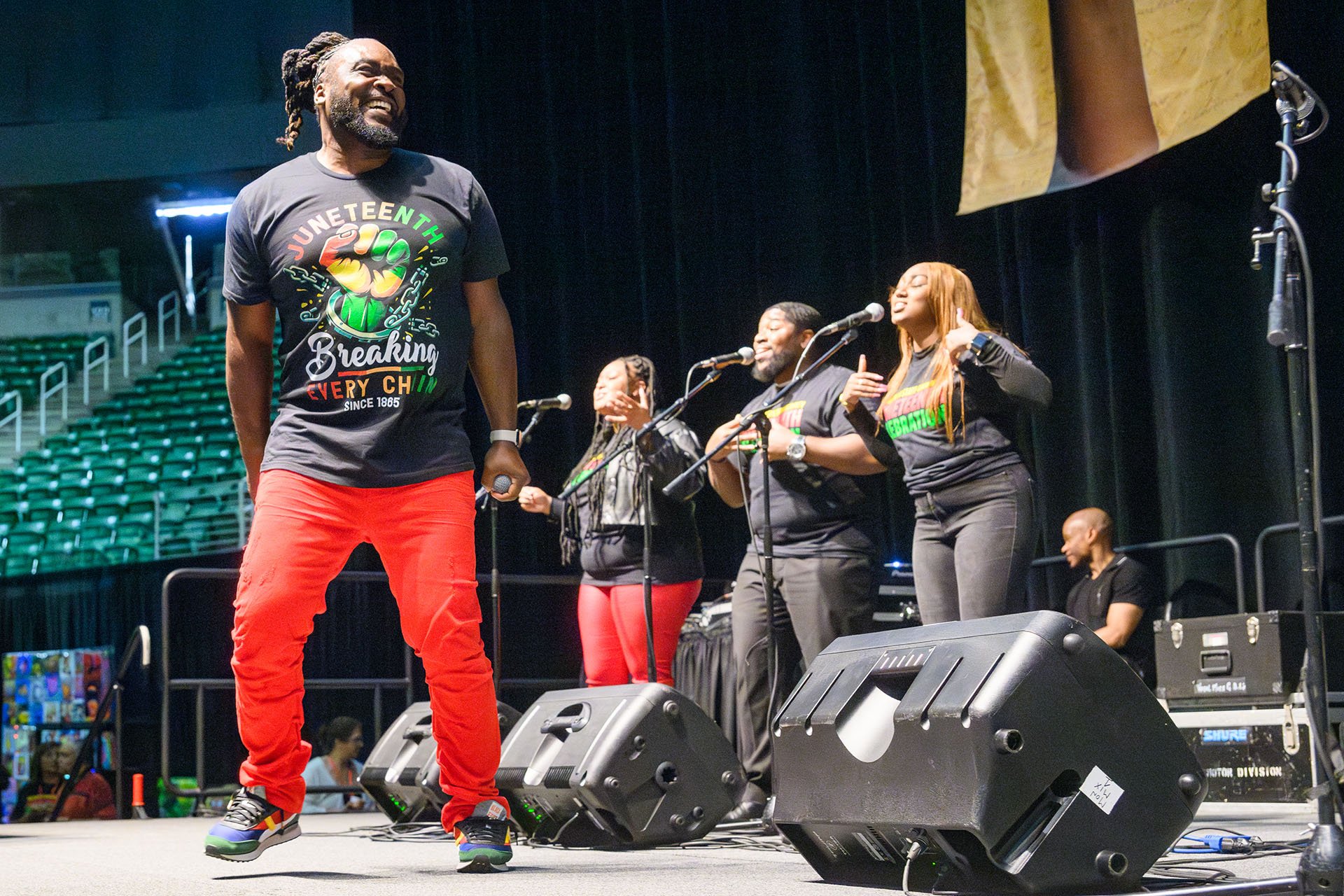 Gregory D dancing on stage with backup singers in the background