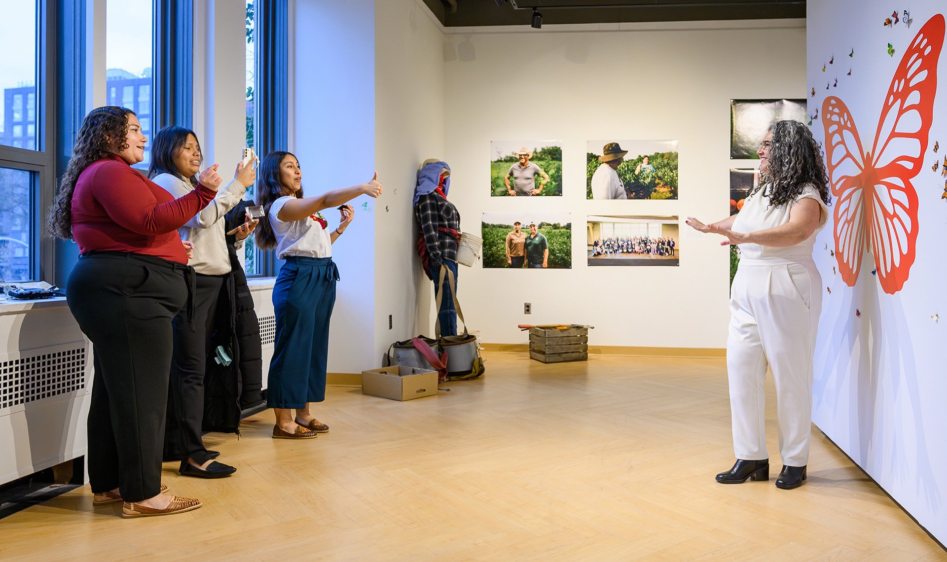 visitors pose for a photo with the butterfly wing backdrop