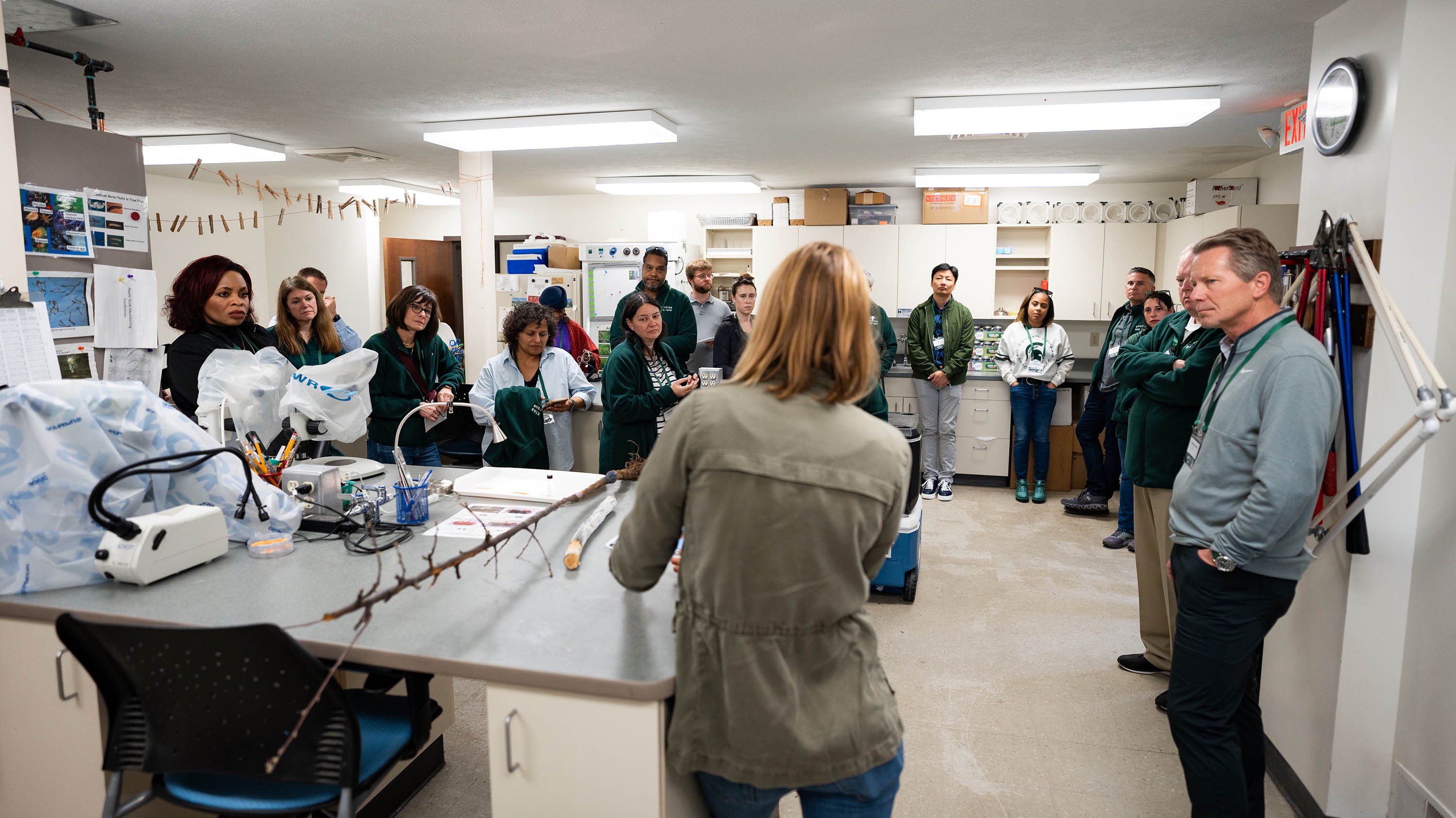 A group listens to a demonstration in a research lab.