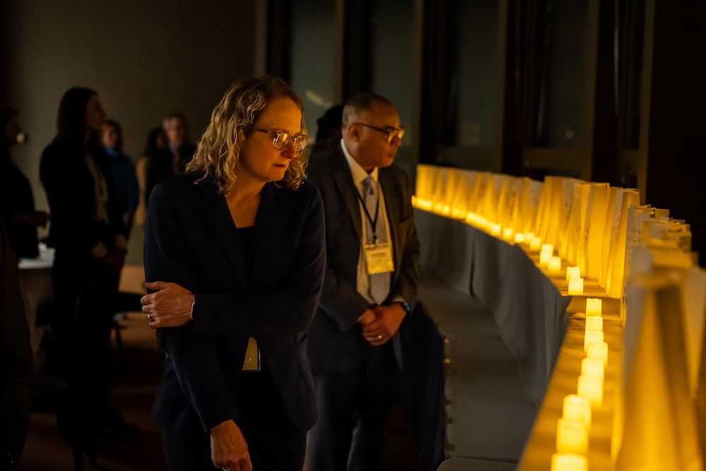 Andrea Wendling, senior associate dean of academic affairs for the MSU College of Human Medicine, walking past luminaries. Photo credit Bryan Esler.