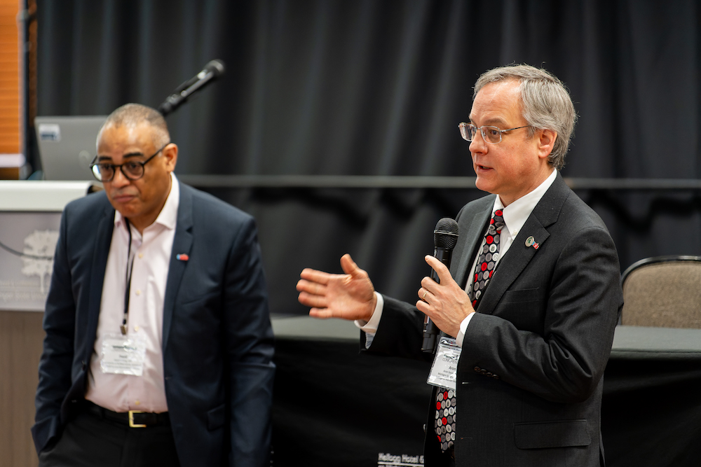 David Milling from the Jacobs School of Medicine and Biomedical Sciences at the University at Buffalo and Aron Sousa, dean of the MSU College of Human Medicine, speak on how the conference came together. Photo credit Bryan Esler.