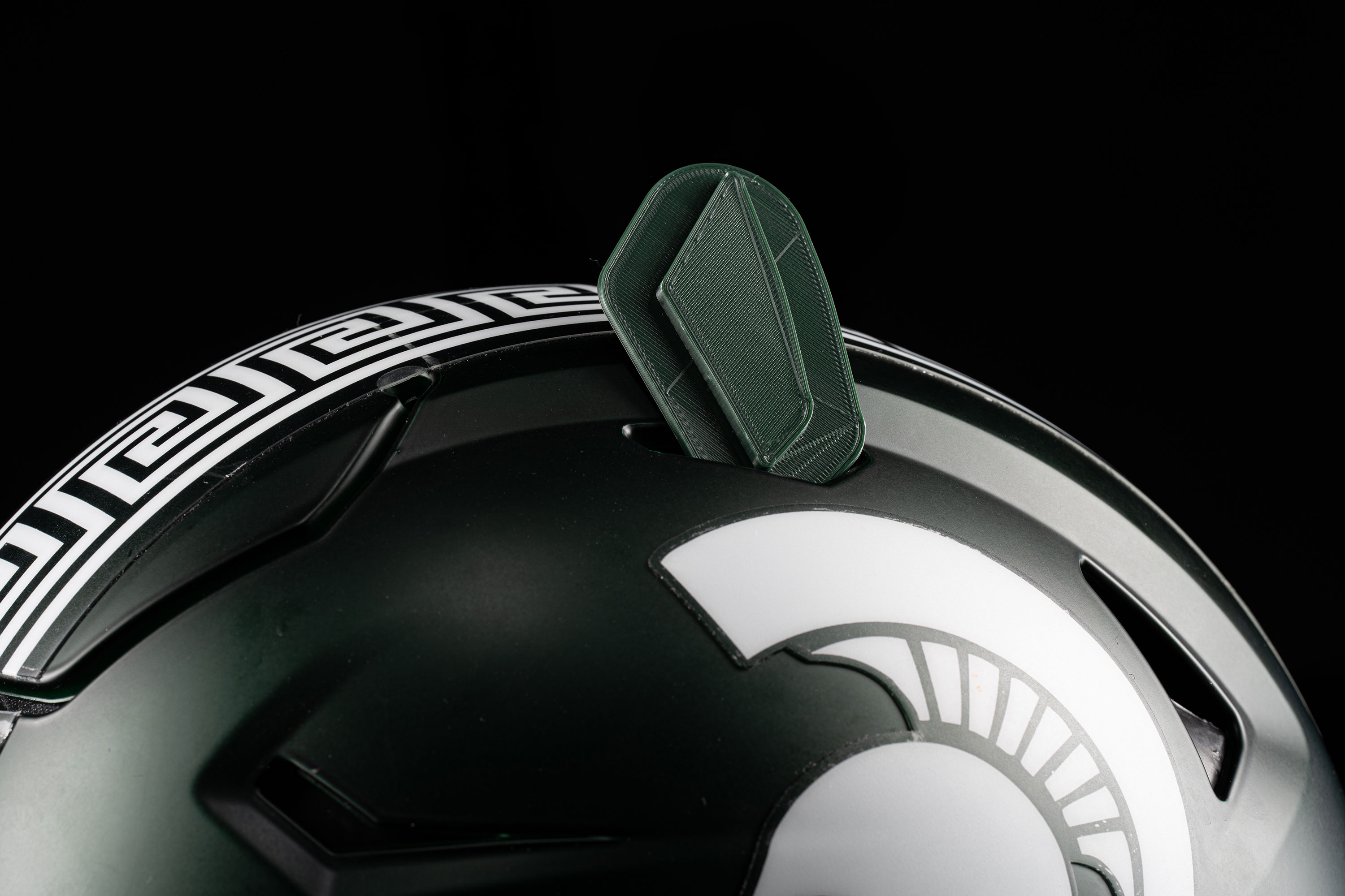 A green plastic insert displayed on top of a green football helmet.