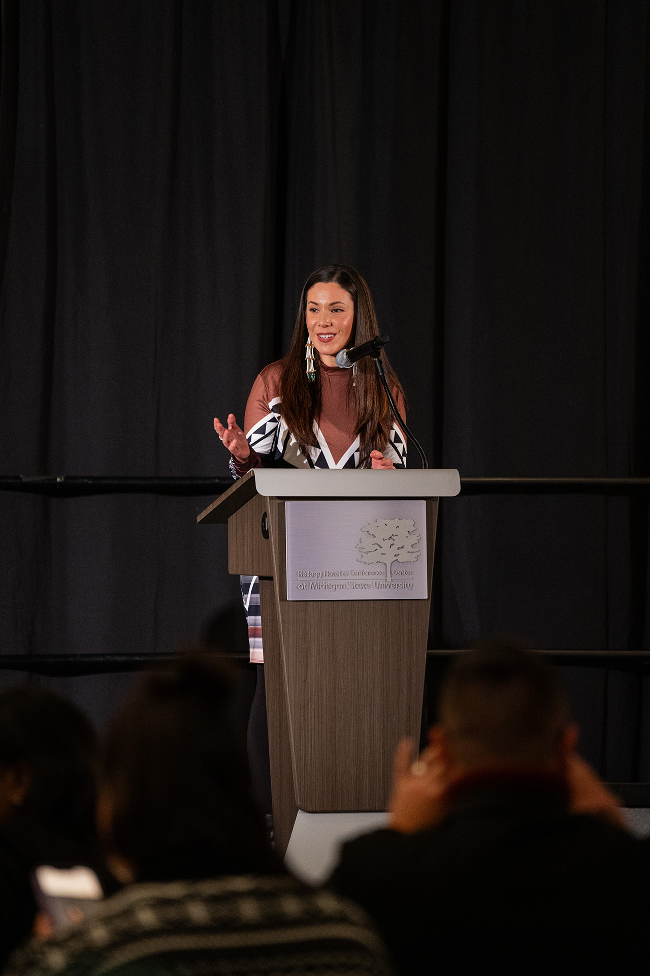 Blaire Moreseau standing a the lectern addressing the audience