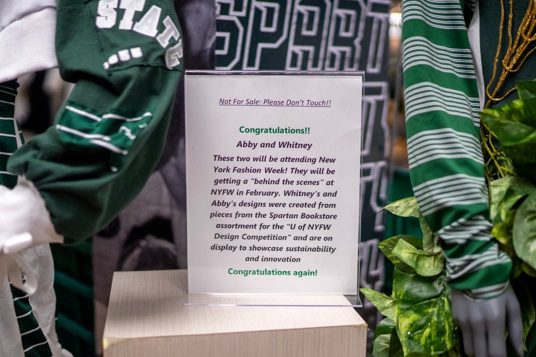 The sign that accompanies the winning designs created by Abigail Jones and Whitney Howard that are displayed at the Spartan Bookstore in MSU’s International Center through Feb. 9.