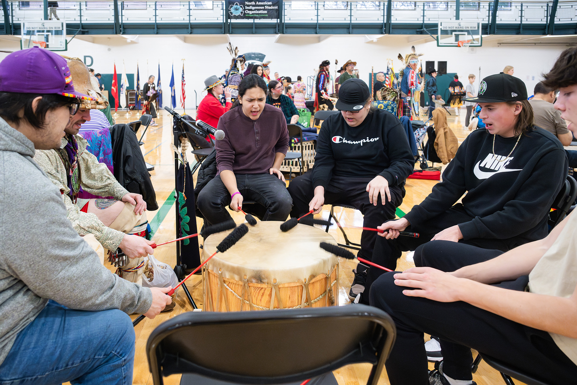 Drummers sit in a circle singing