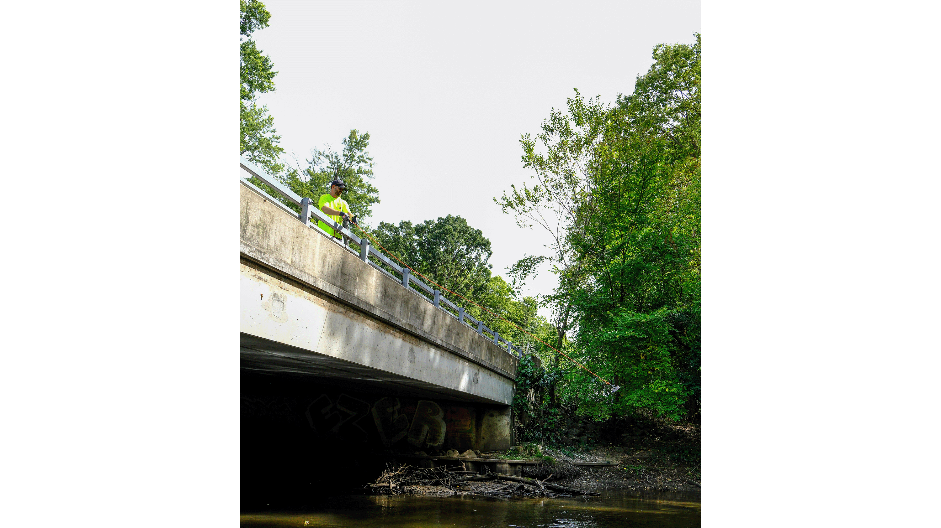 Person magnet fishing over bridge