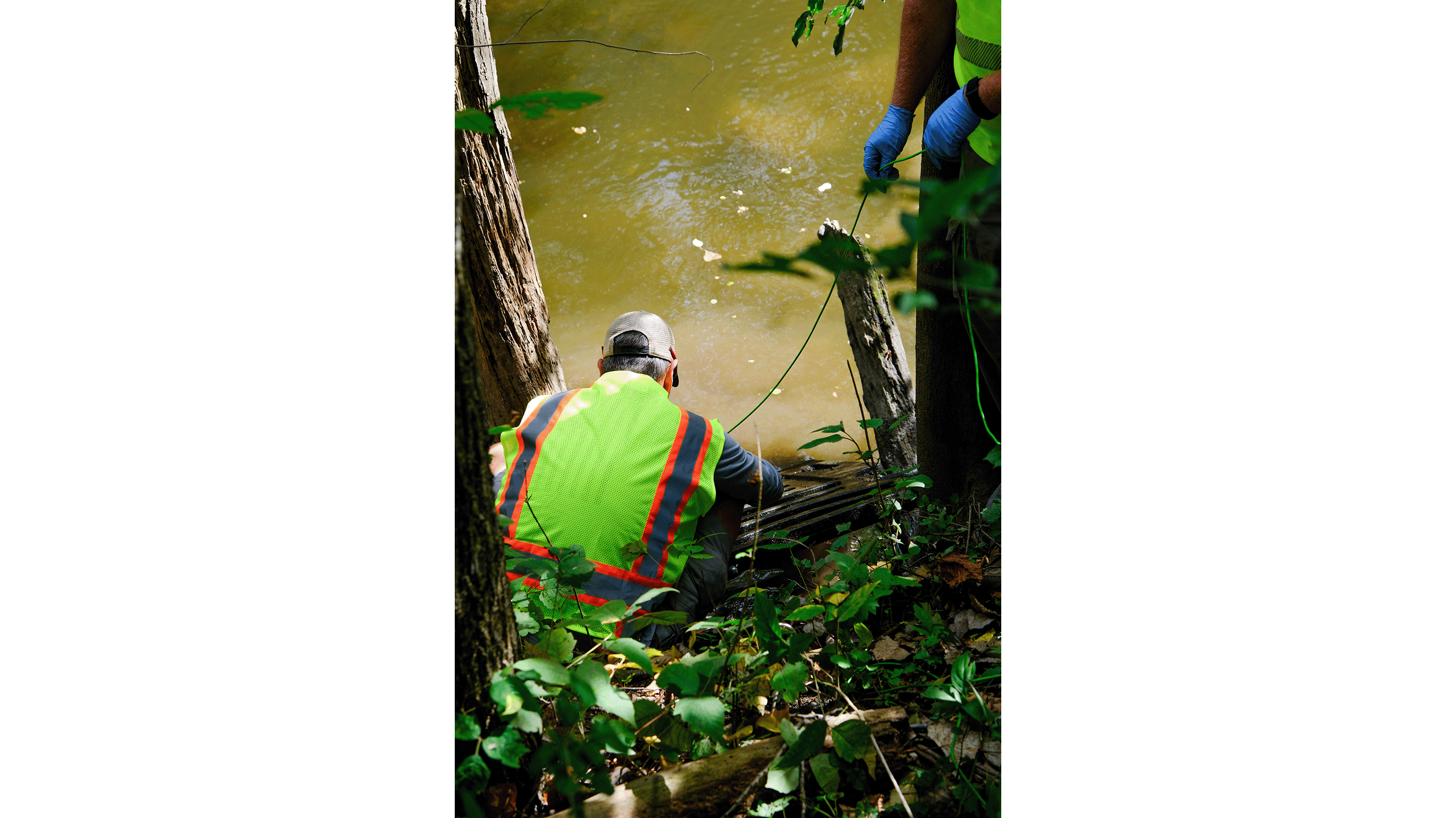 Workers pulling plastic out of river