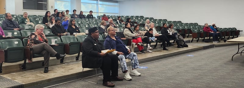 Participants attend an event in a lecture room facing the front room