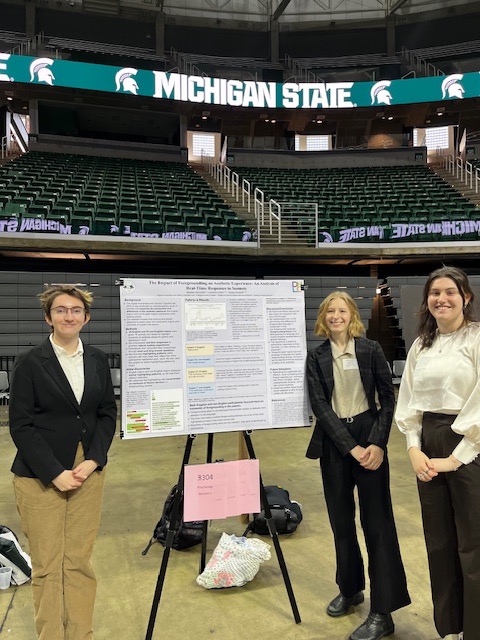 Lorraine Inman, Natalie Liliensiek and Gracie Rudolfi pose in front of their poster at UURAF in April on the floor of the Breslin Student Events Center