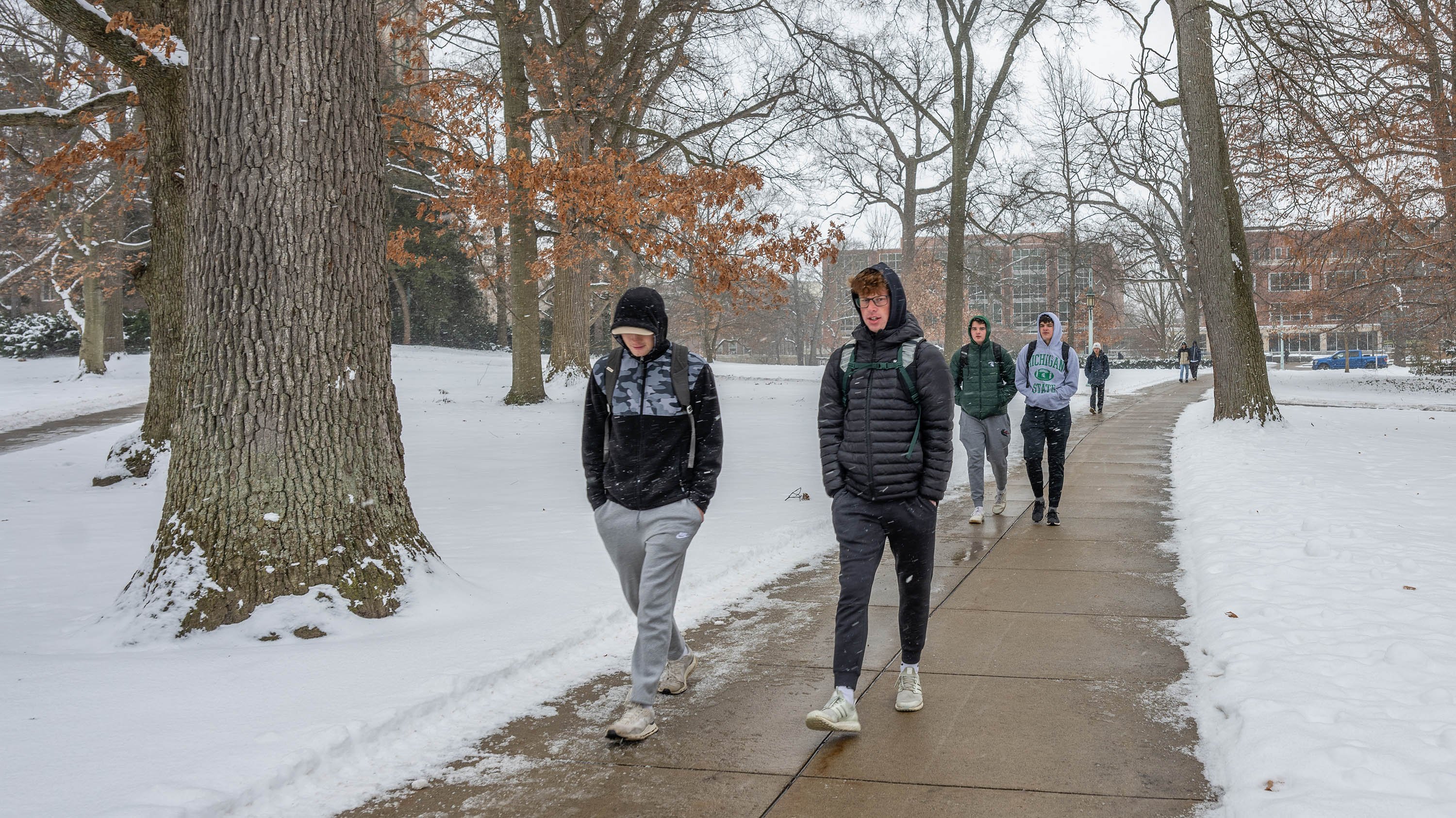 Students walking on sidewalk in winter