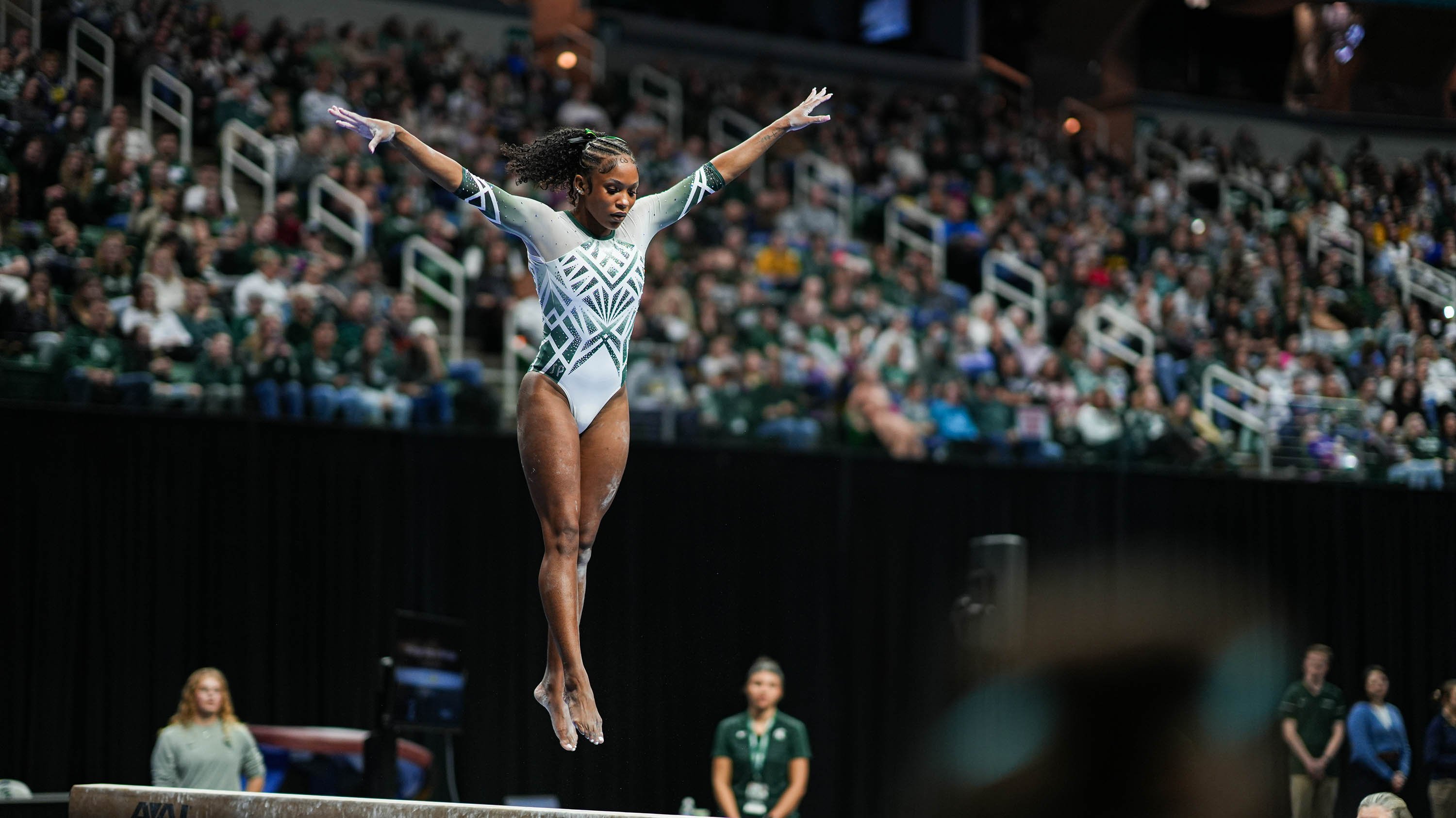 Gymnast doing a jump on balance beam