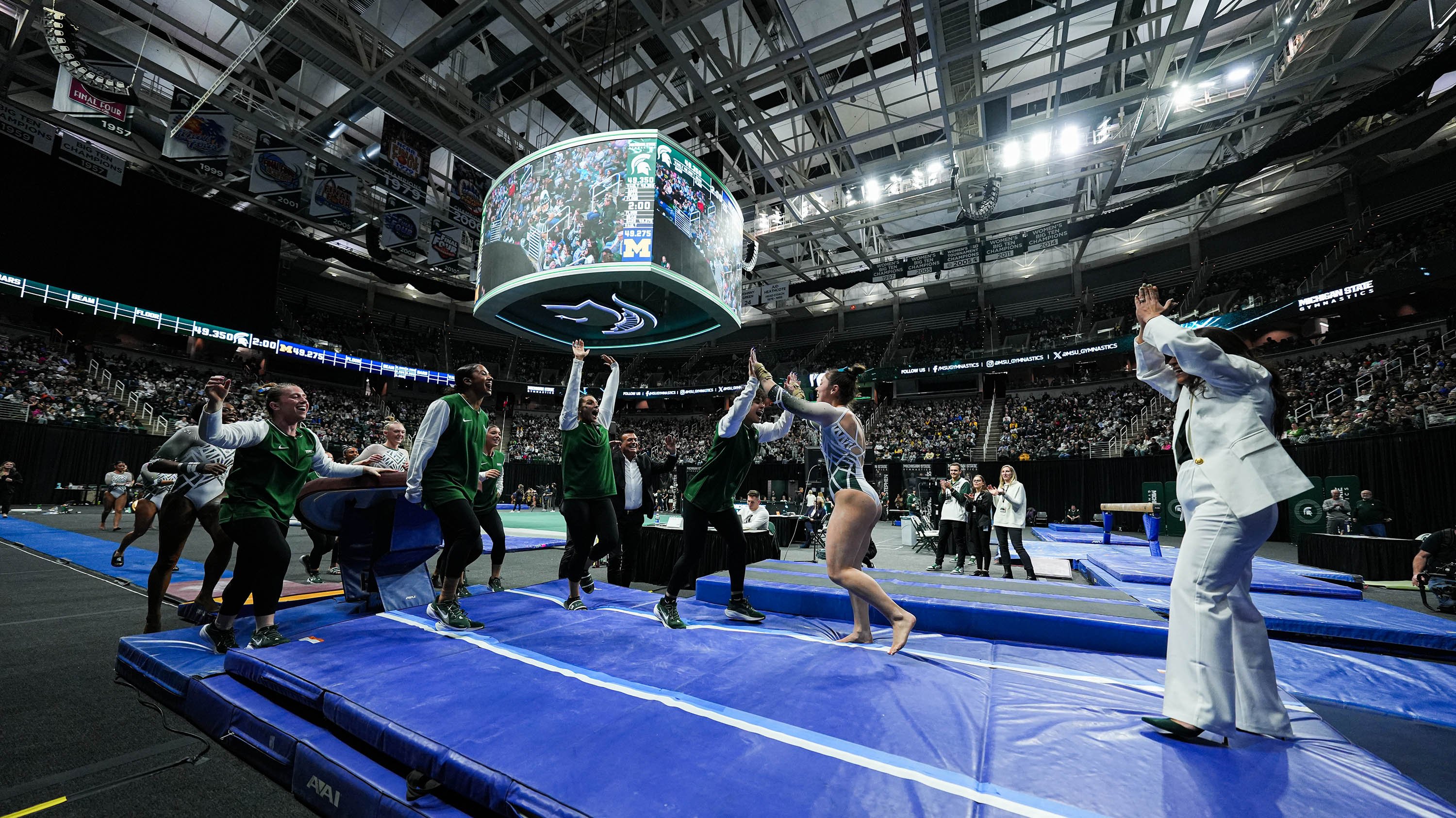 Teammates high fiving at MSU gymnastics event