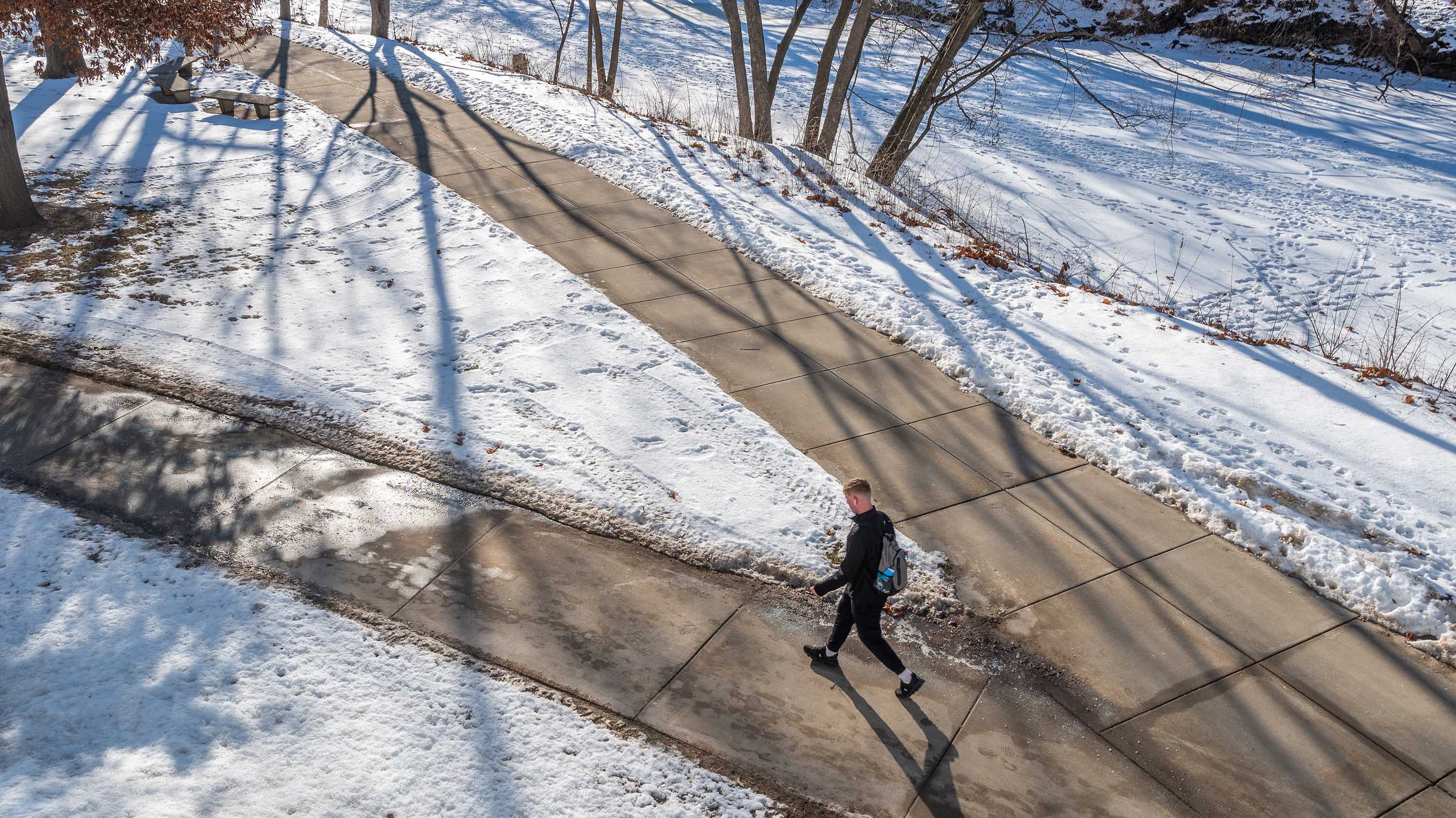 Person walking on sidewalk in winter