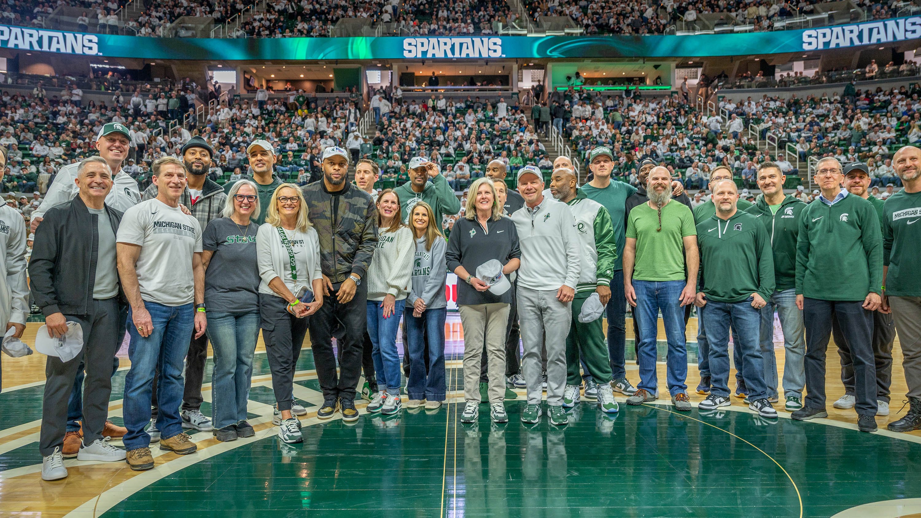 Kevin Guskiewicz and the 2000 men's basketball team on the court at Breslin Center