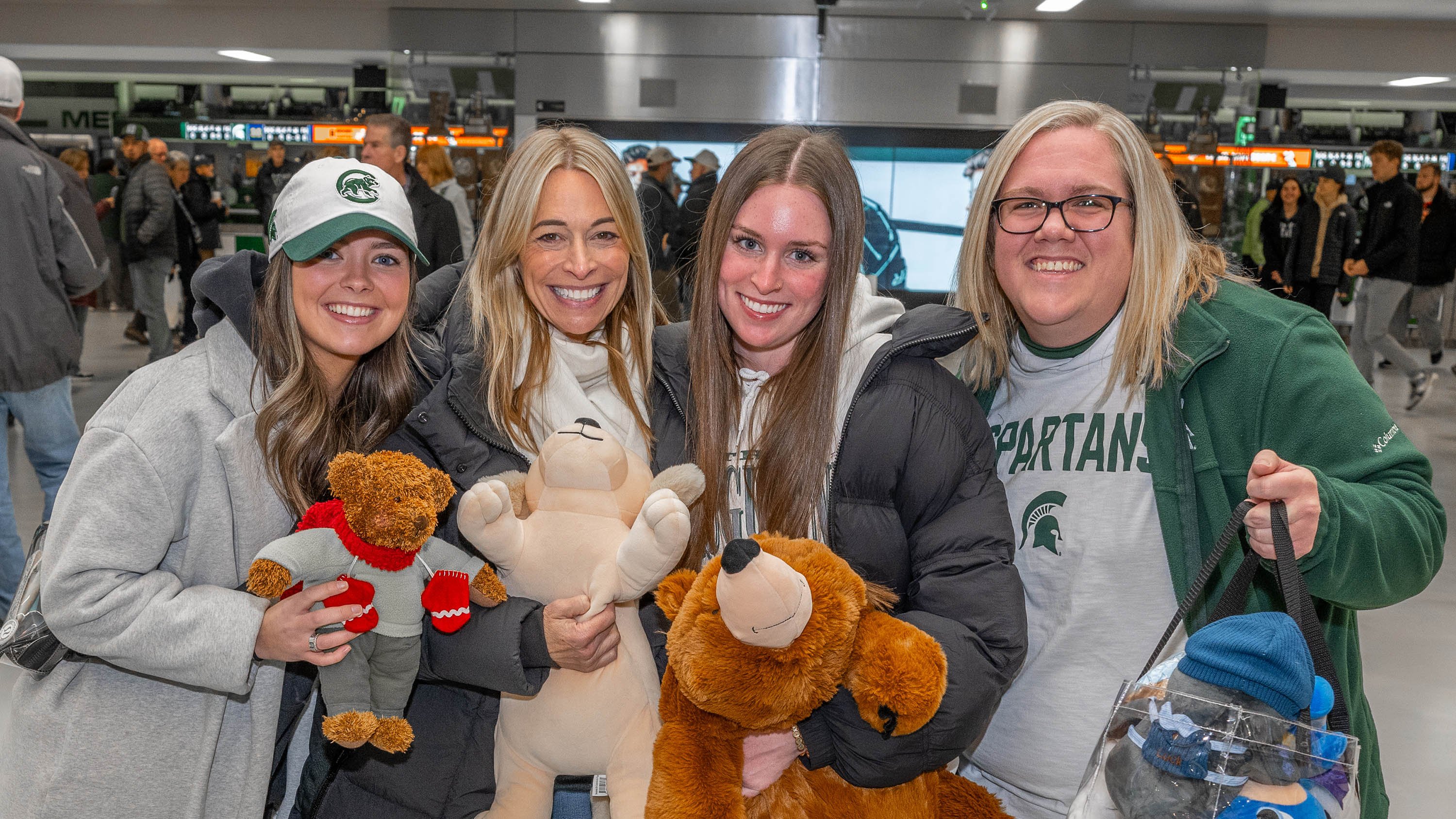 Hockey fans holding stuffed animals outside Munn Ice Arena
