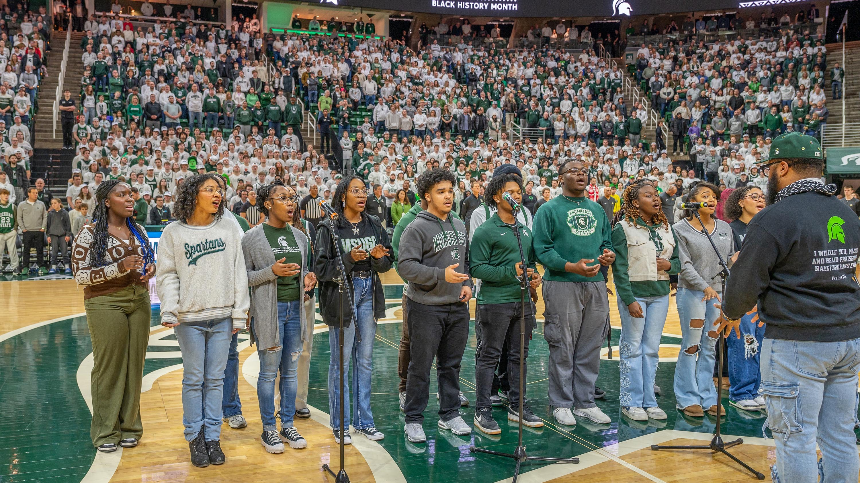 Students singing on the court at an MSU men's basketball game