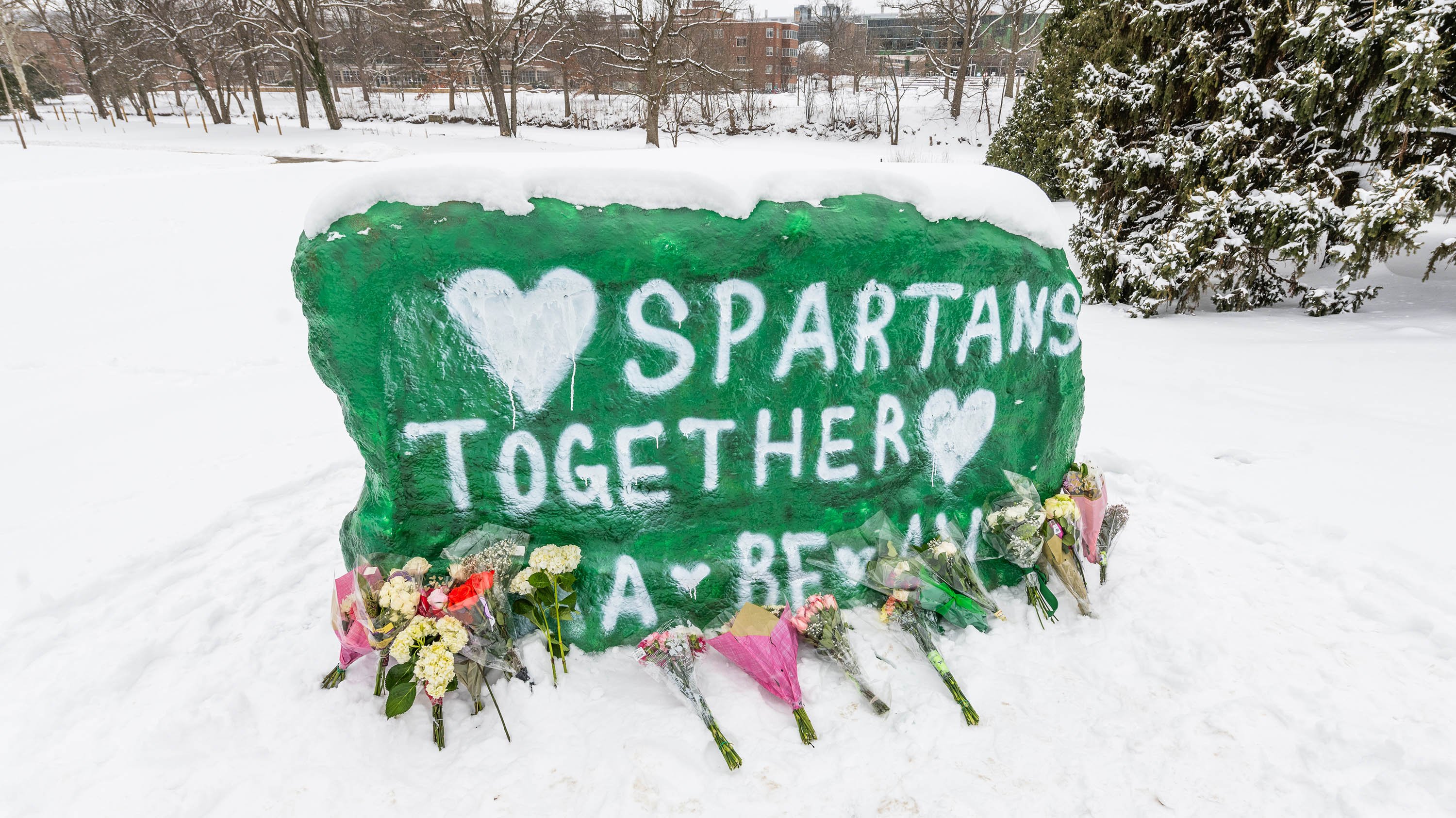 The Rock, with flowers placed in front and the painted text Spartans together on its surface