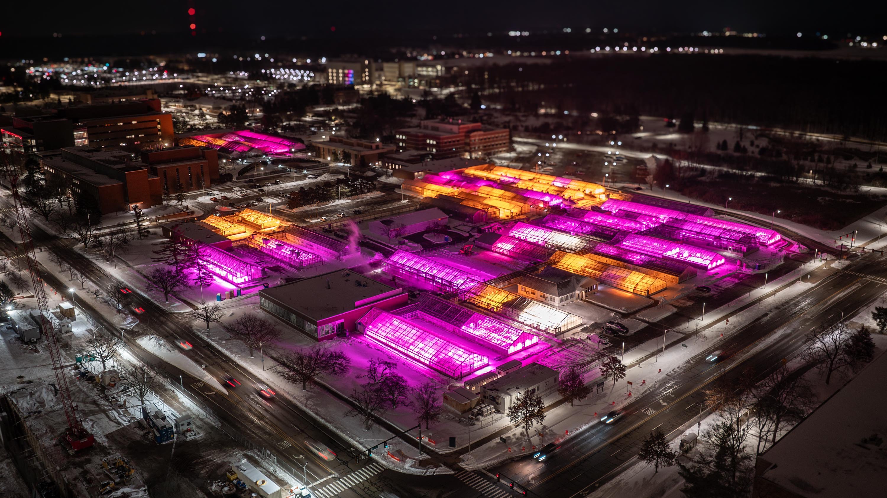 Greenhouses glowing pink and orange at night