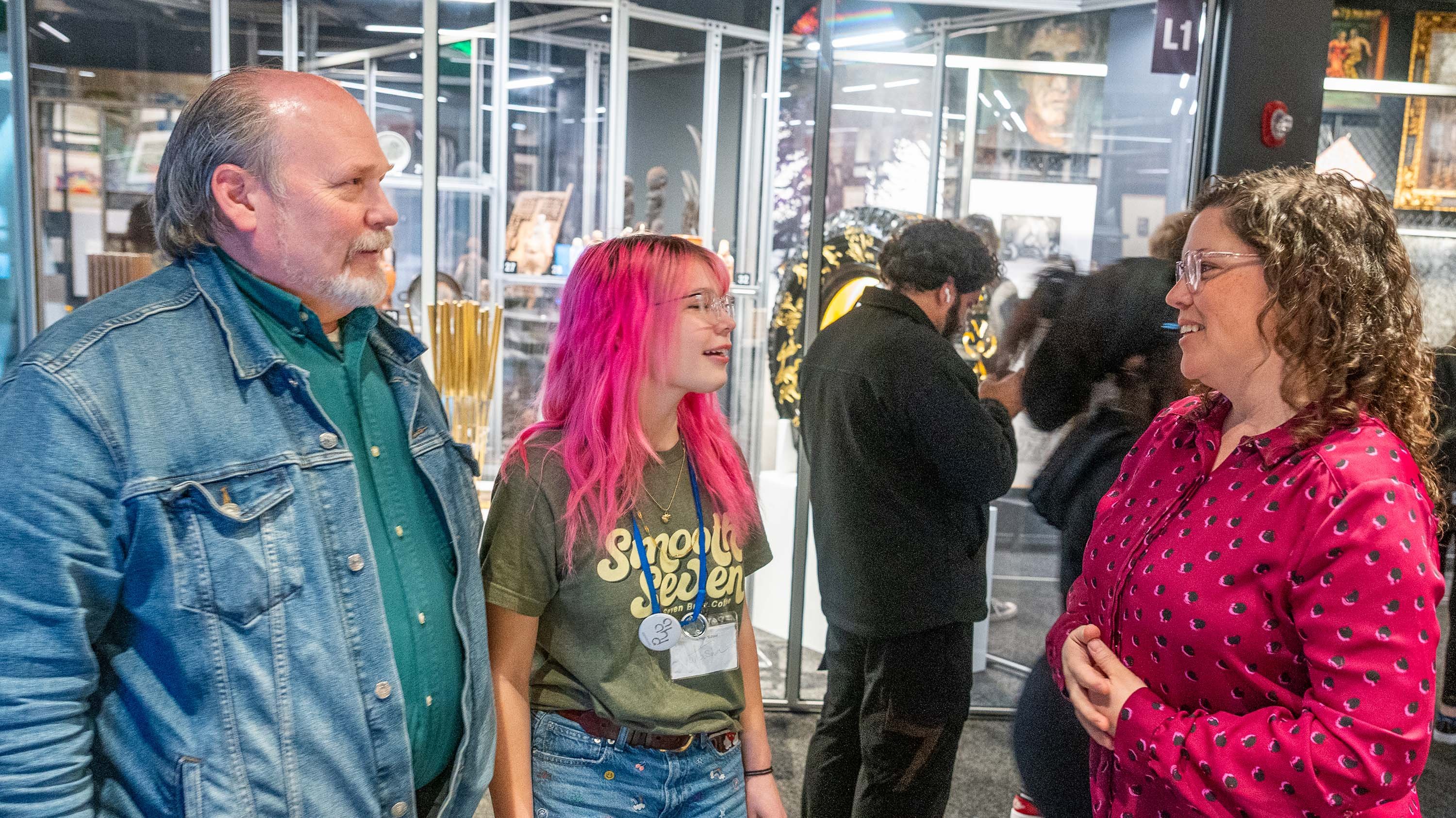 Parent and high school student speaking to Meghan Collins in MSU Broad Museum CORE