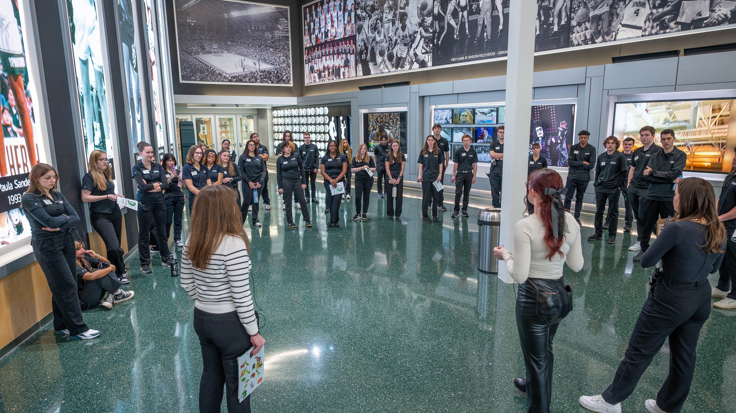 Ushers in a meeting in the lobby of the Breslin Center