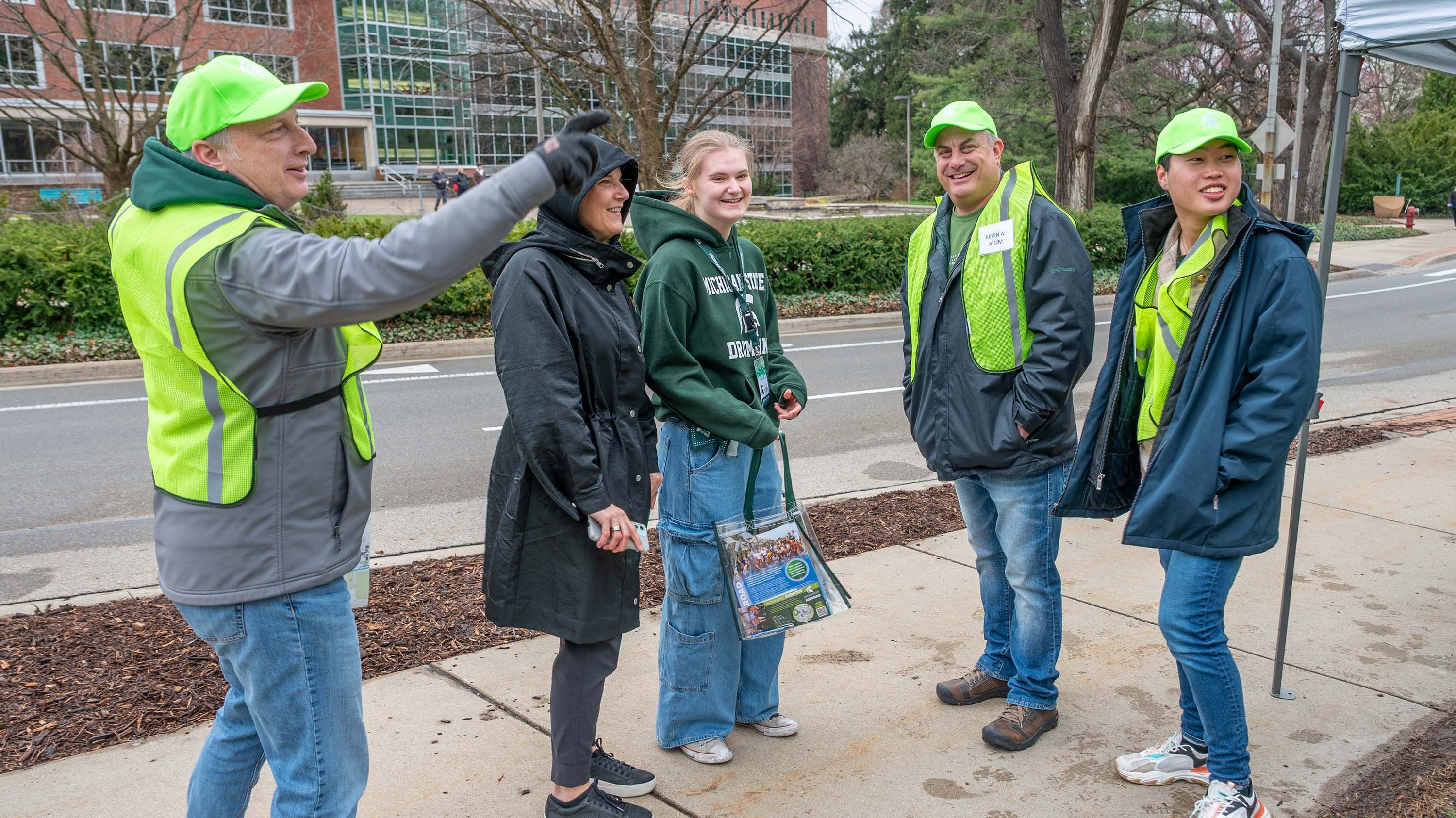 Parent and student receiving directions from alumni volunteers