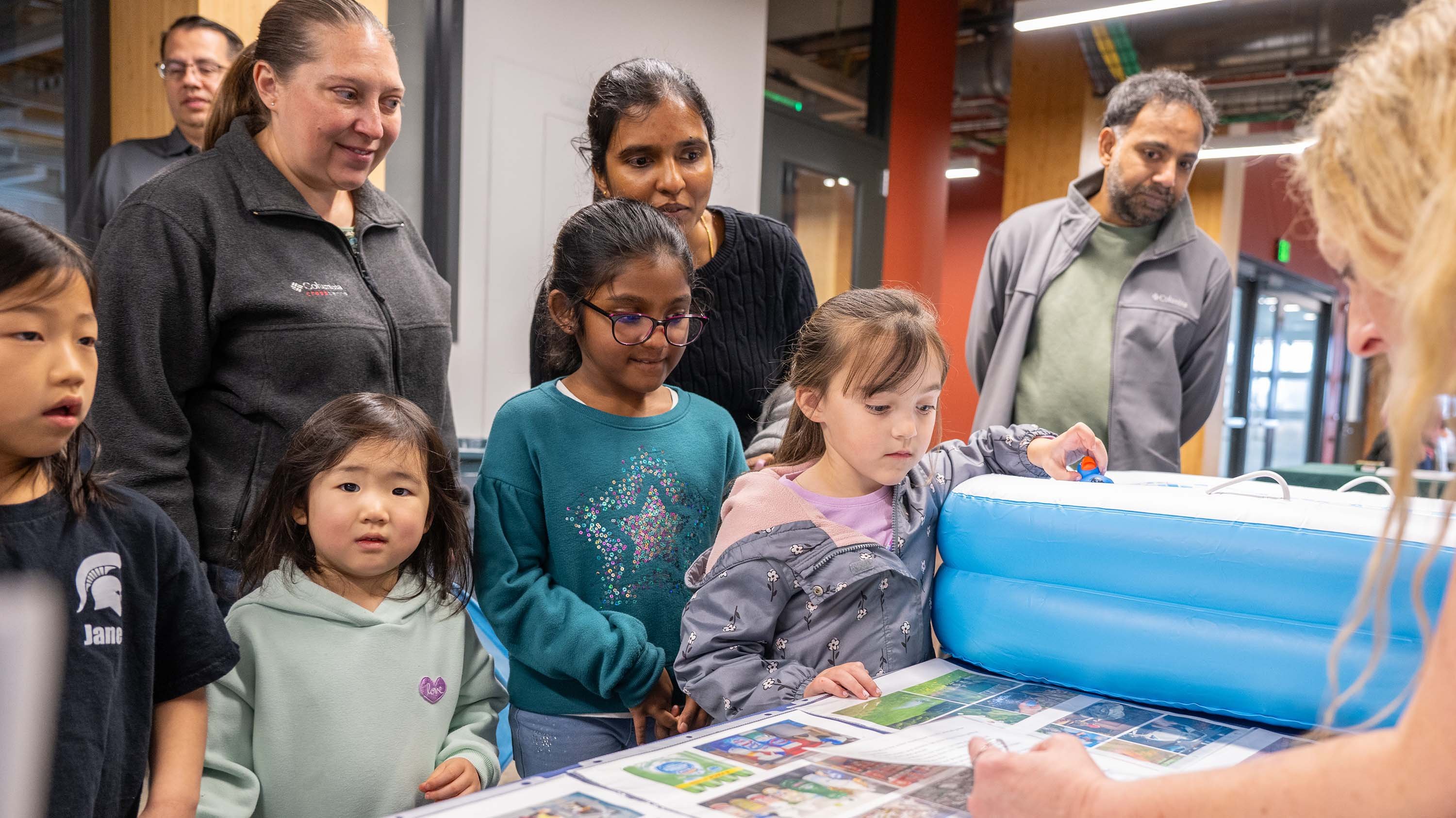 Children and parents watching science demonstration