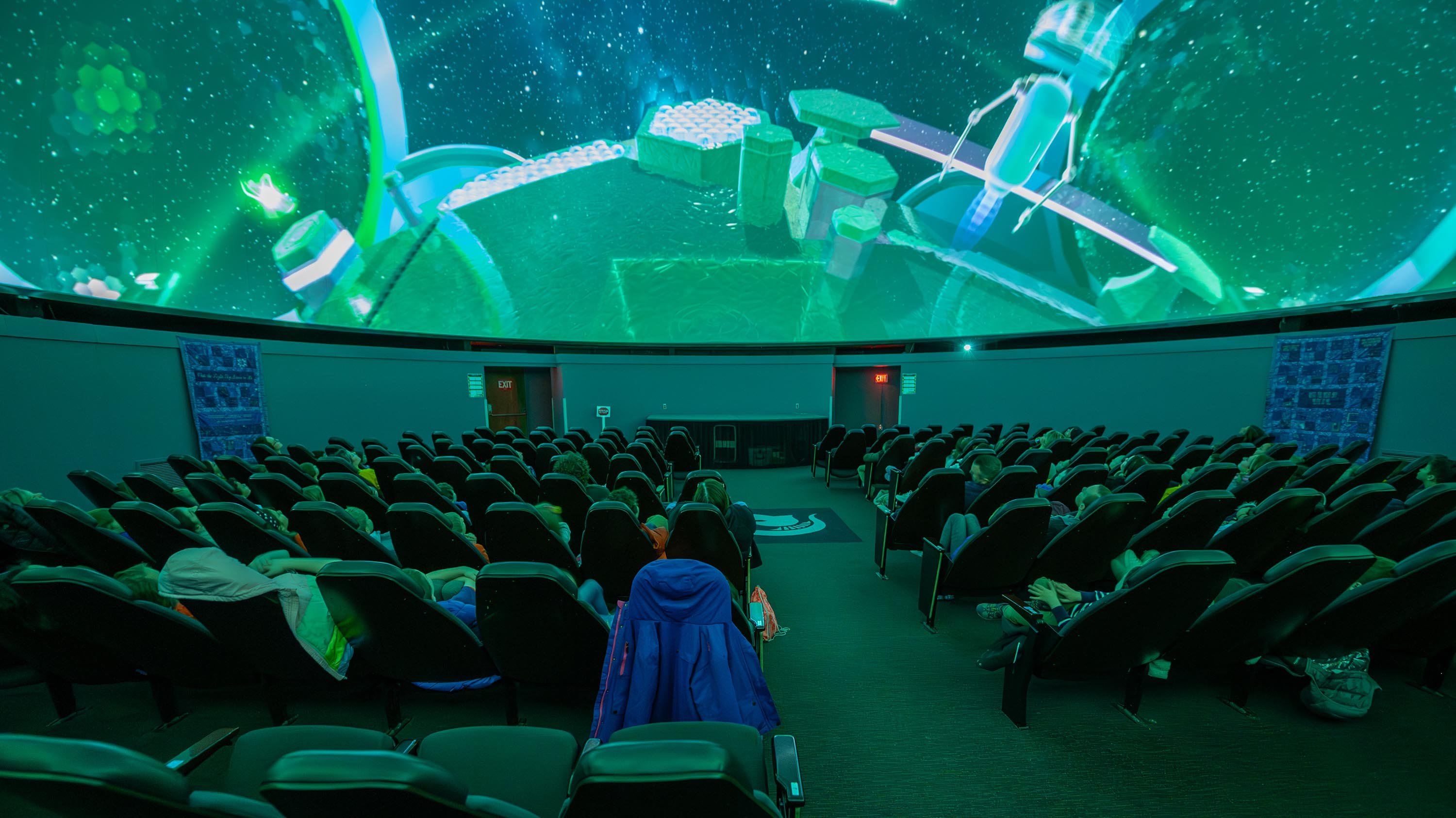 Elementary school students watching show in planetarium