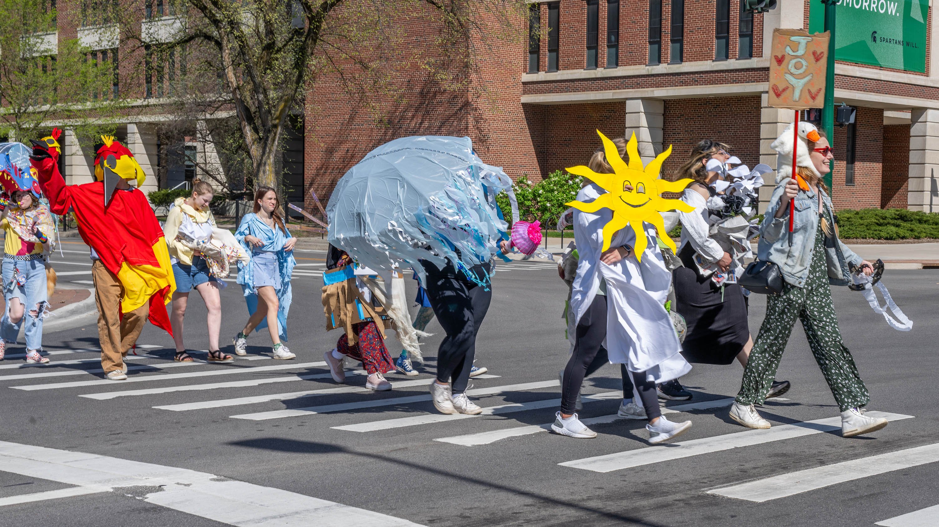 Students in wearable sculptures walking on campus