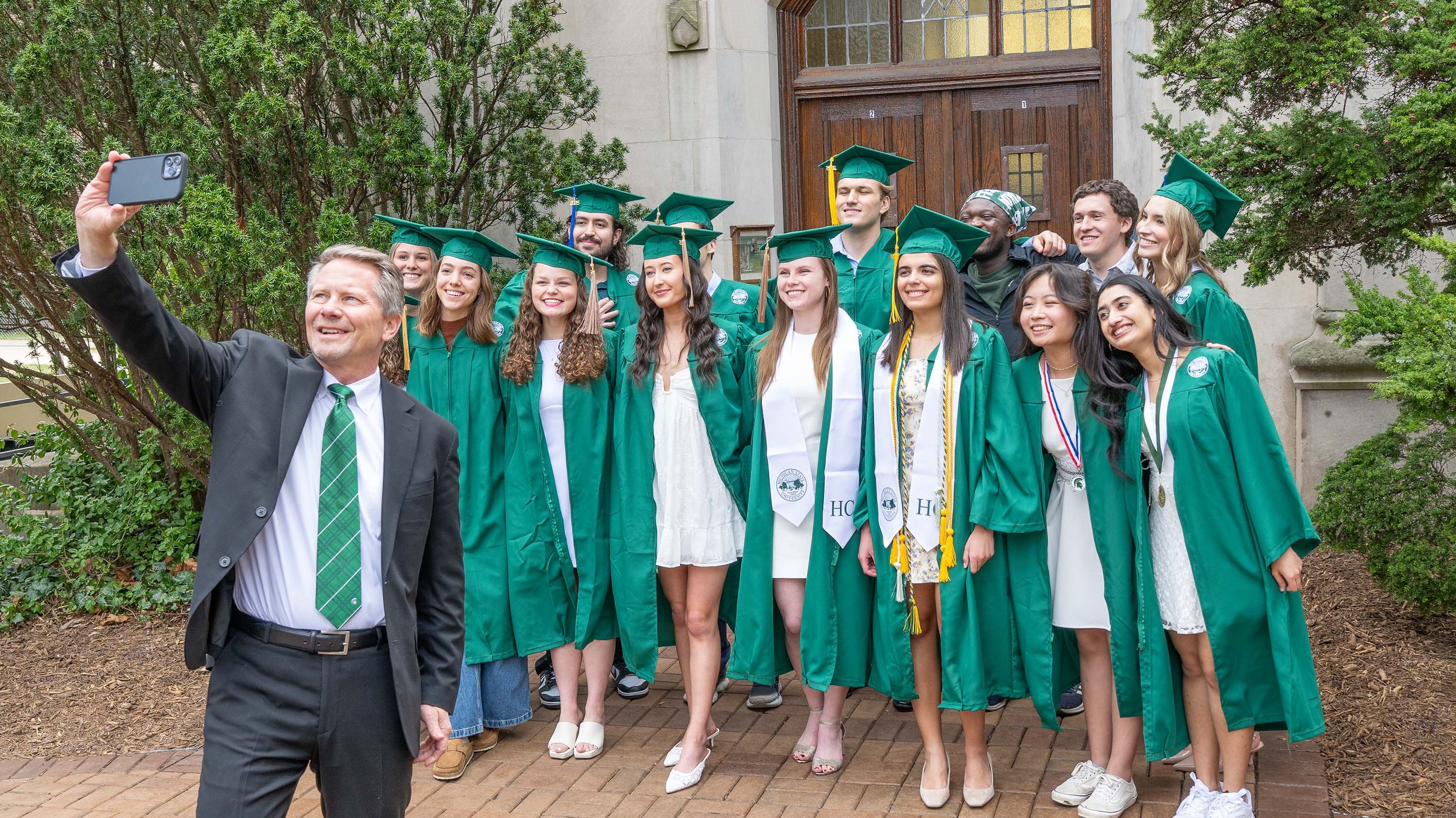President Guskiewicz takes selfie with graduating student