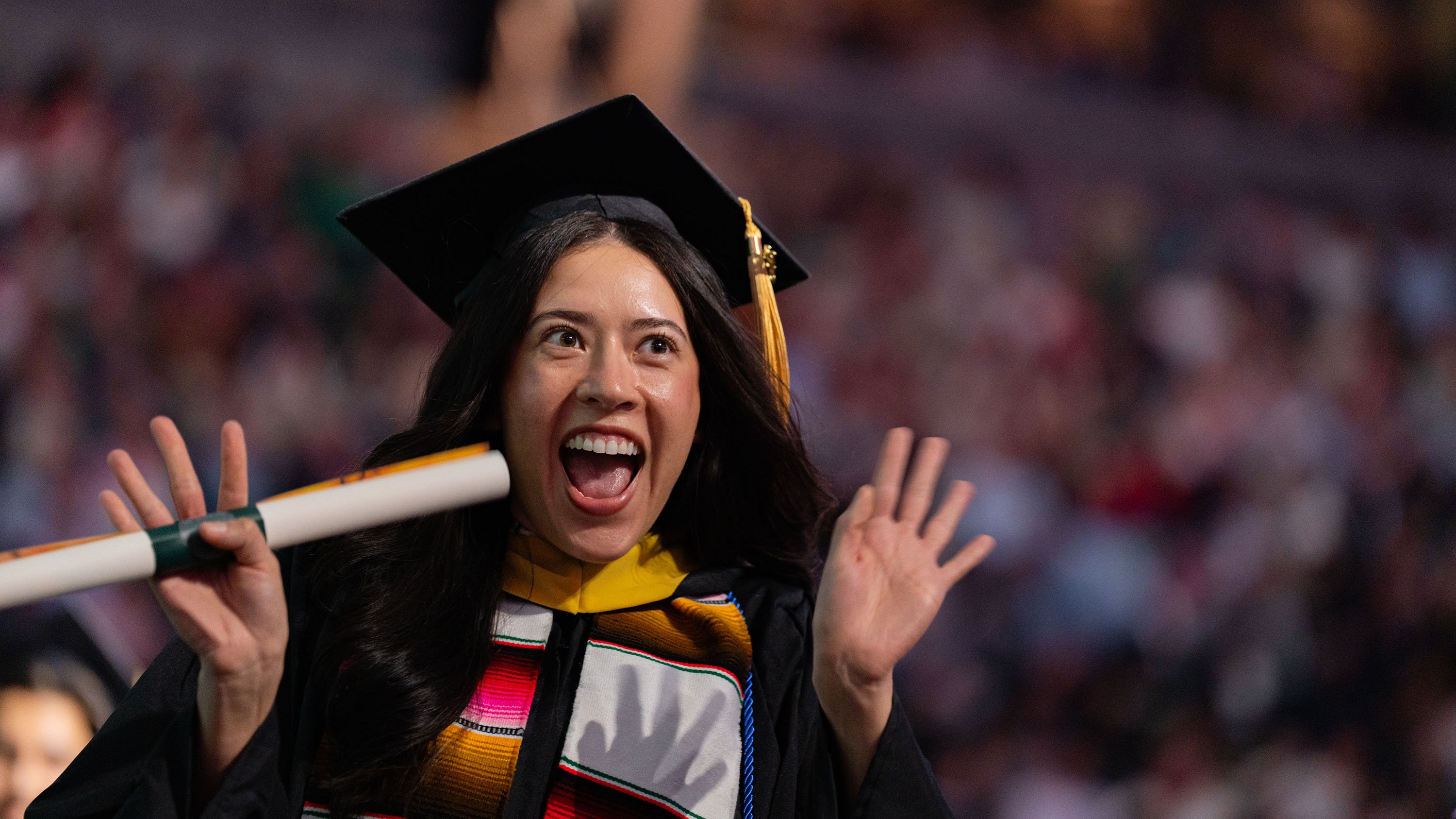 MSU masters graduate smiling and holding diploma