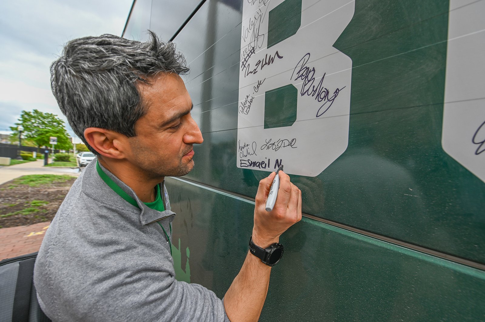 A man writes his signature inside a block letter ?B?